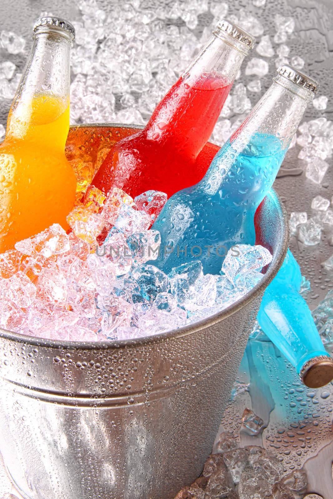 Bottles of cooler drinks with ice on stainless steel counter