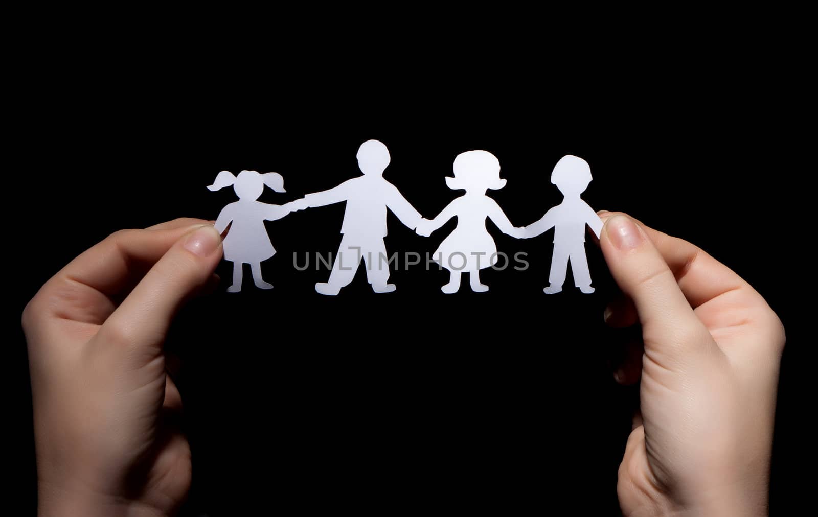 Paper chain family in hands on black background