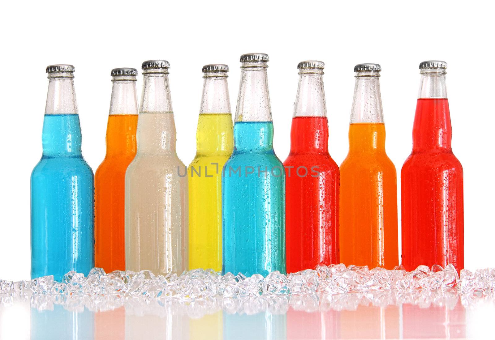 Bottles of multi-color drinks with ice on white background
