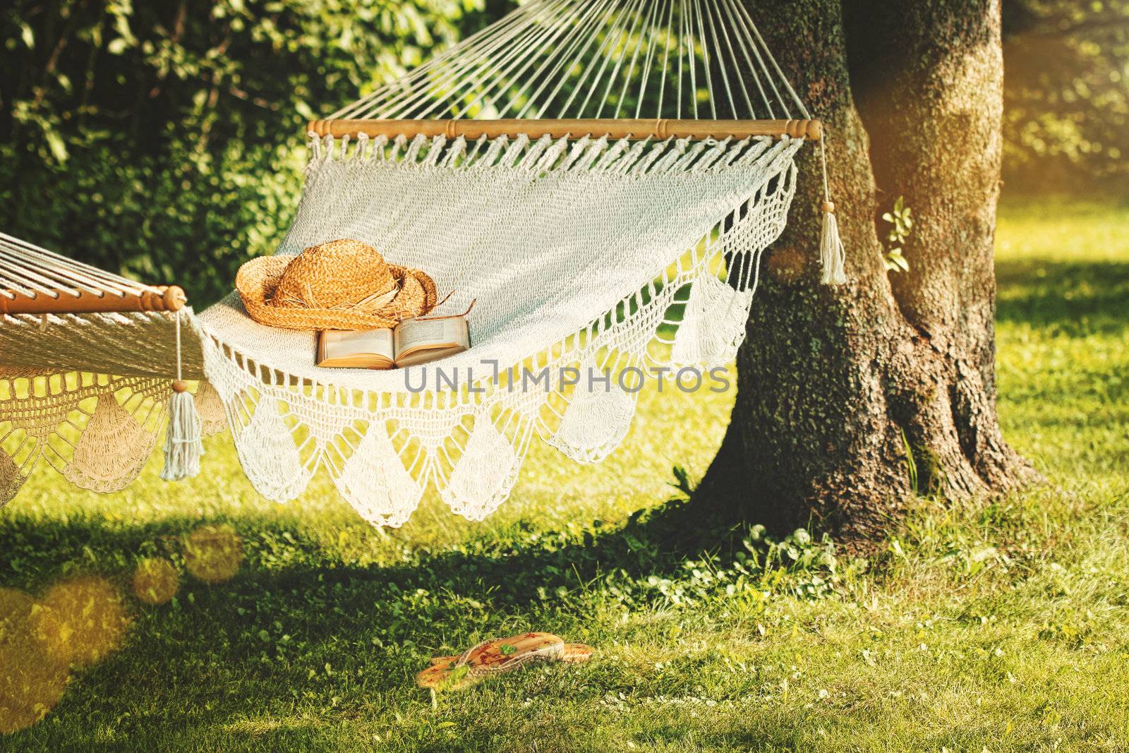 View of hammock and book  on a summer day  by Sandralise