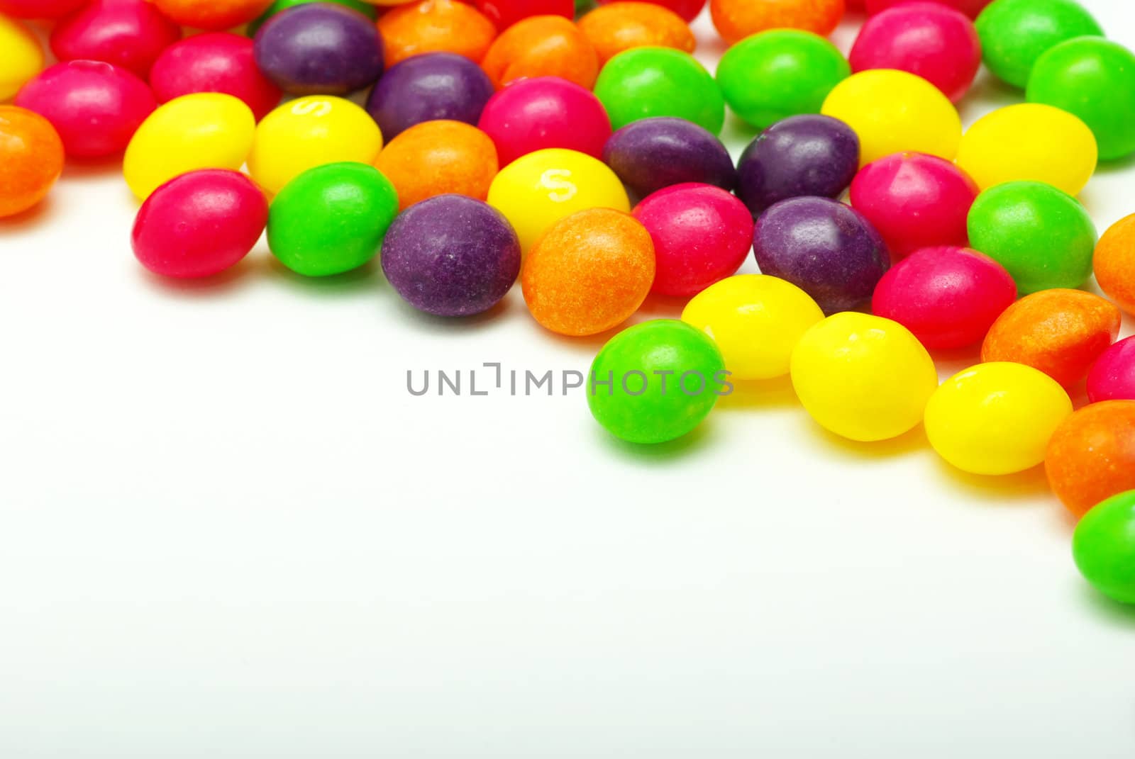 Set of sweet dragees of different color on white background