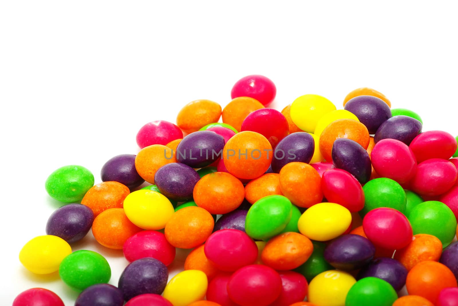 Set of sweet dragees of different color on white background