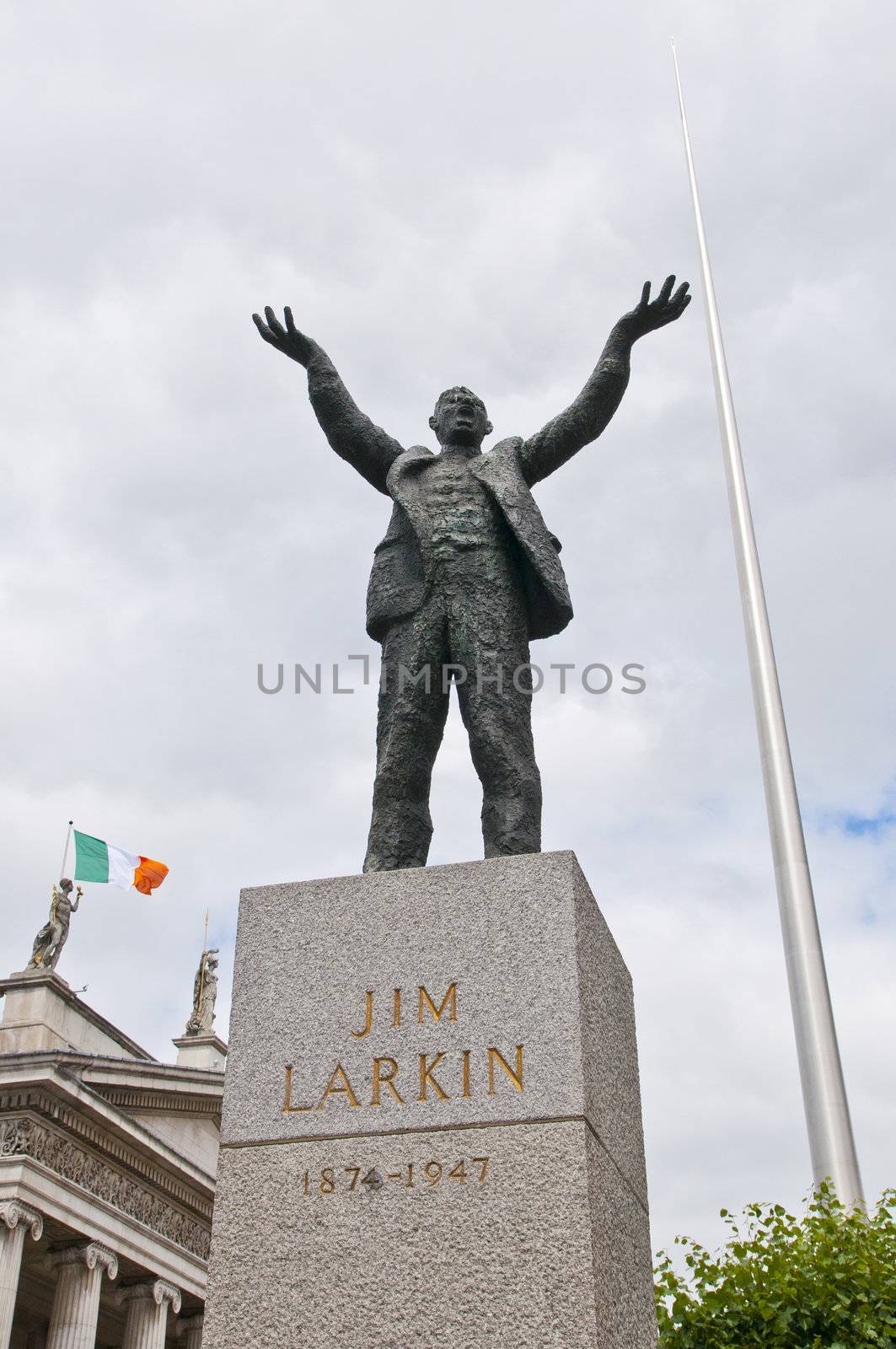 Statue of Jim Larkin with Millenium Spire and Irish flag in the background in OConnell Street, Dublin, Ireland