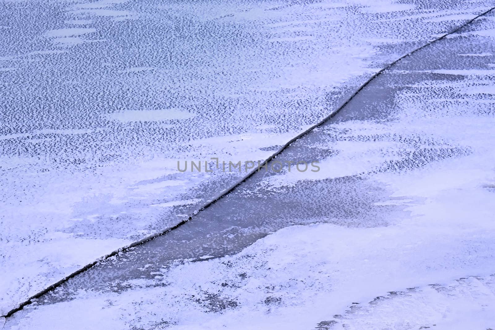 A long crack on the thin snowy ice water reservoir