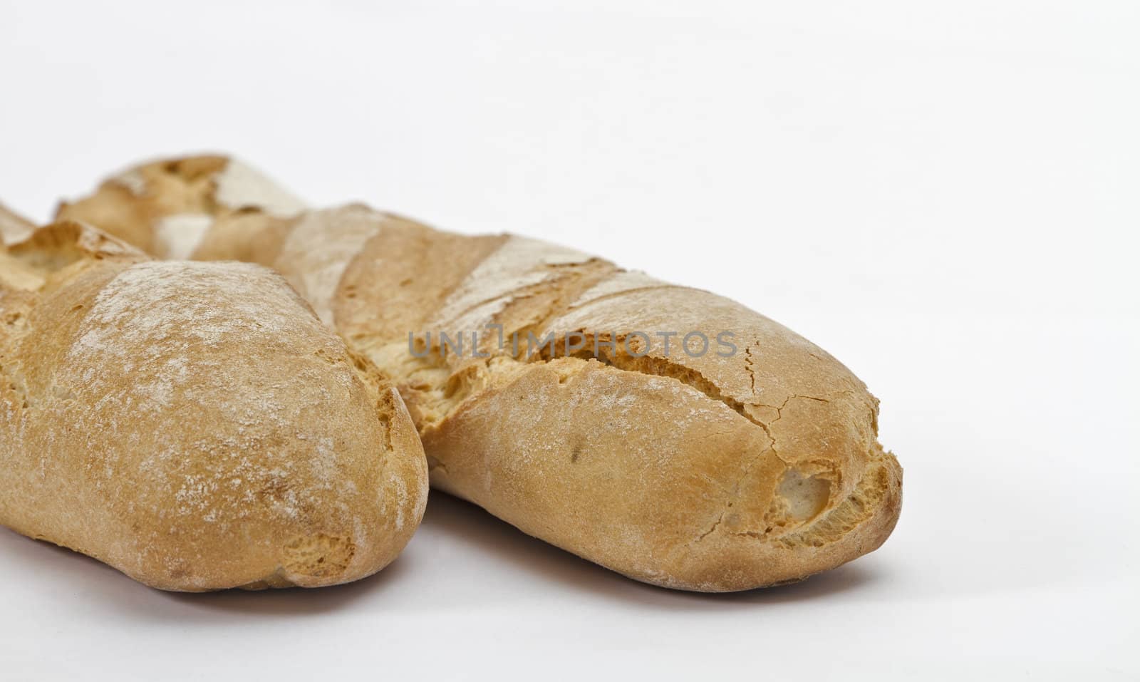 part of two baguettes on light background
