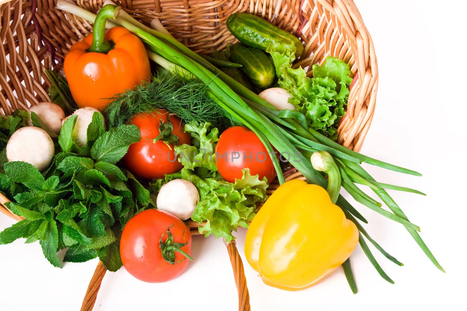 Basket with vegetables isolated on white background.