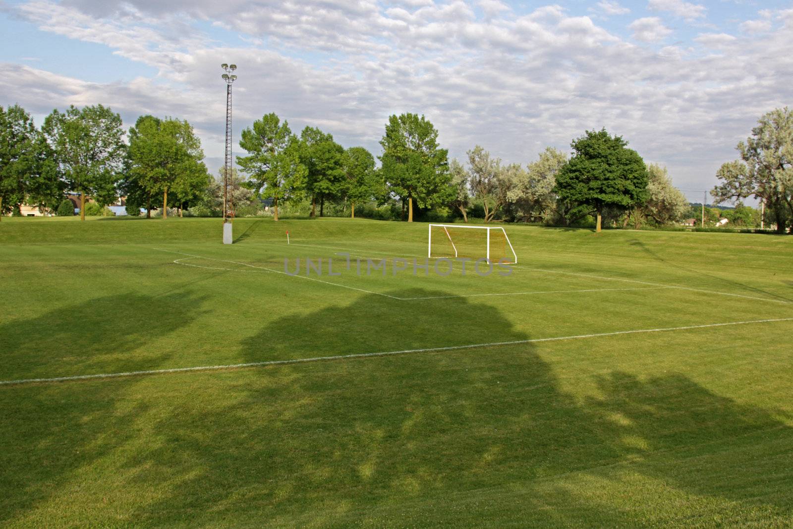 A cloudy unoccupied soccer field with trees in the background. (HDR photograph)
