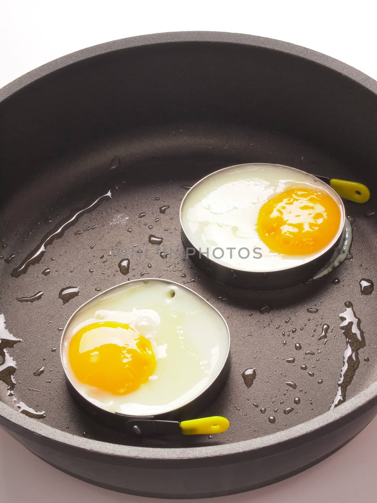 close up of fried eggs in a pan