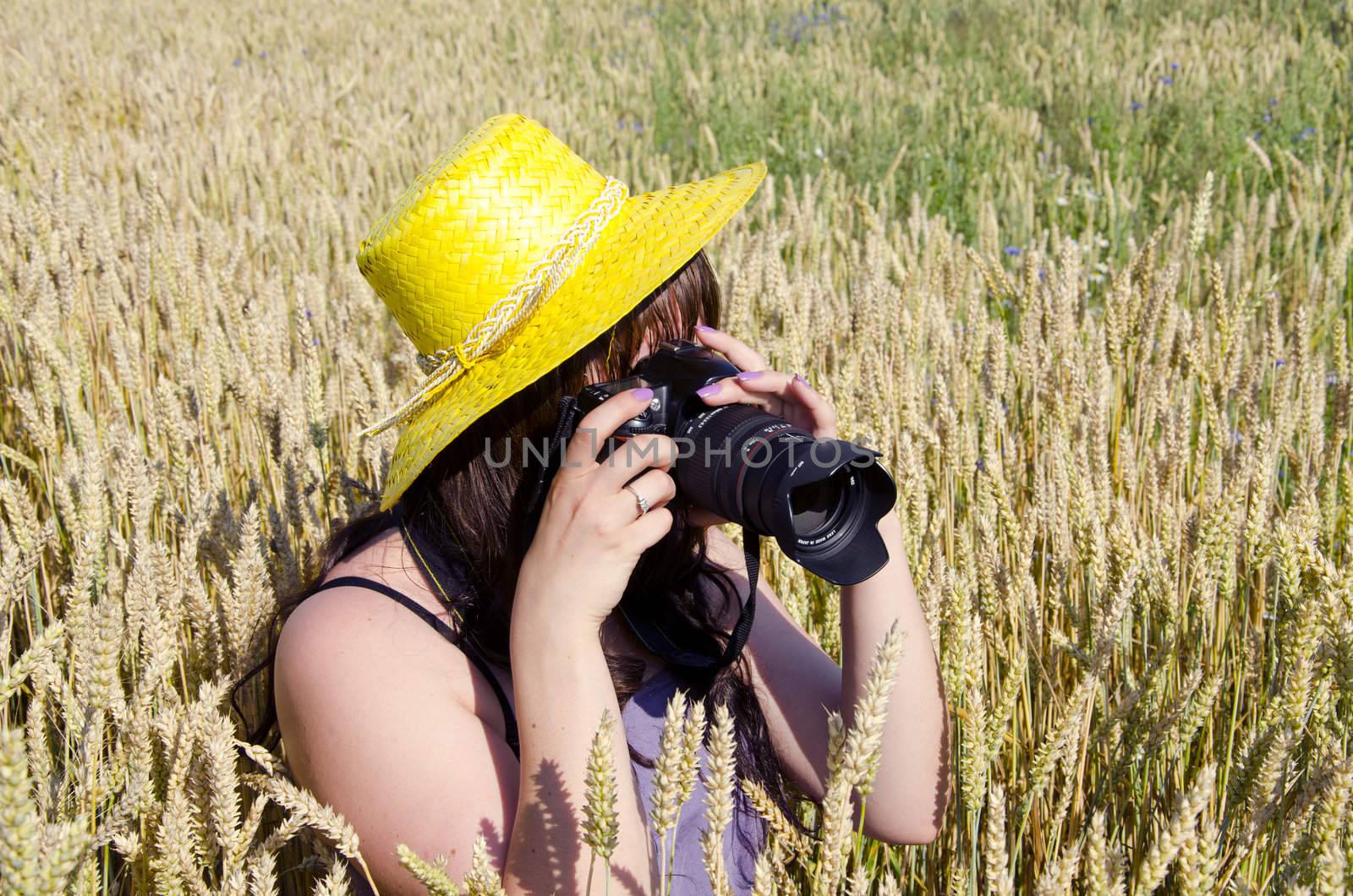 Woman taking shots in field of wheat. by sauletas