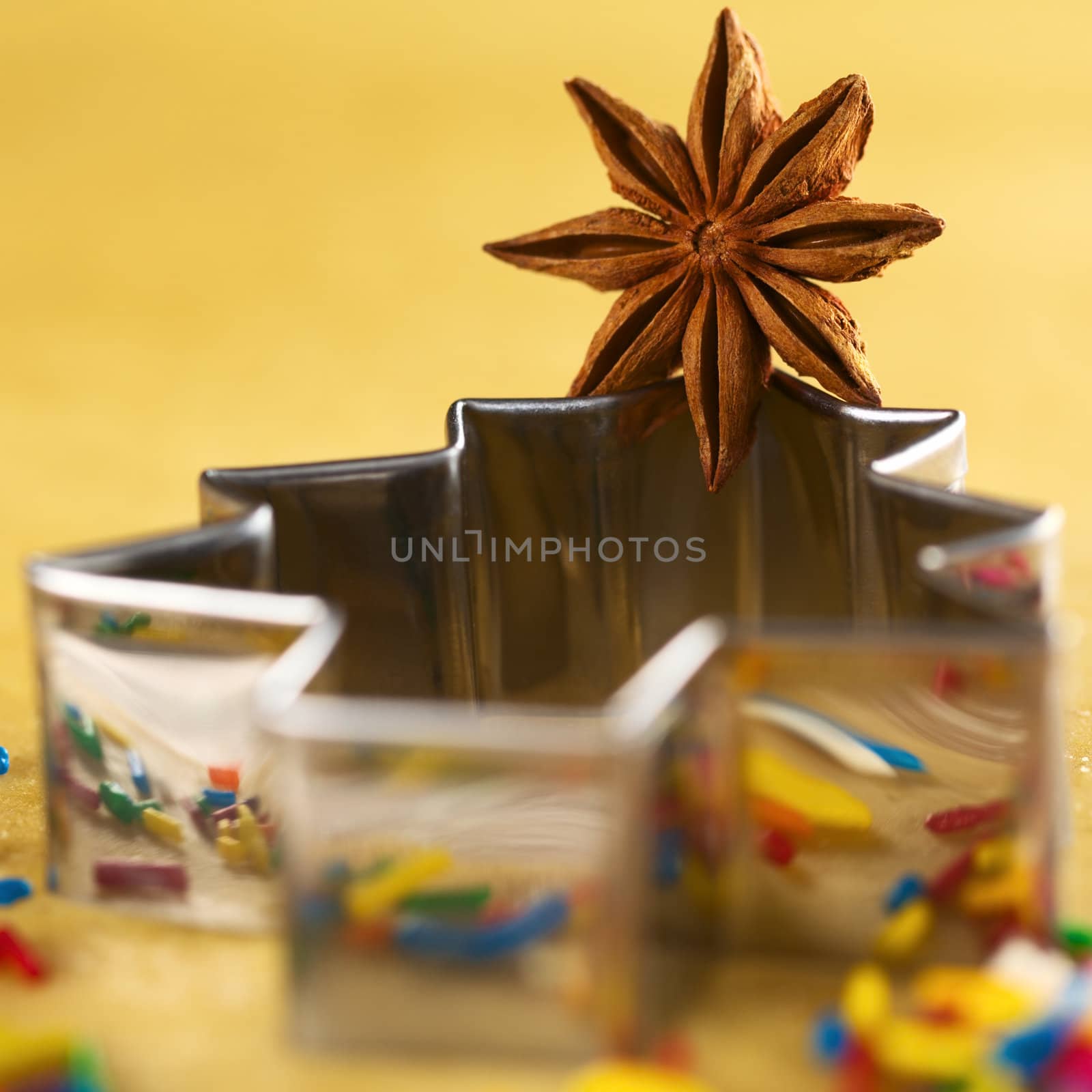 Star anise on Christmas tree shaped cookie cutter lying on dough (Selective Focus, Focus on the middle of the anise)