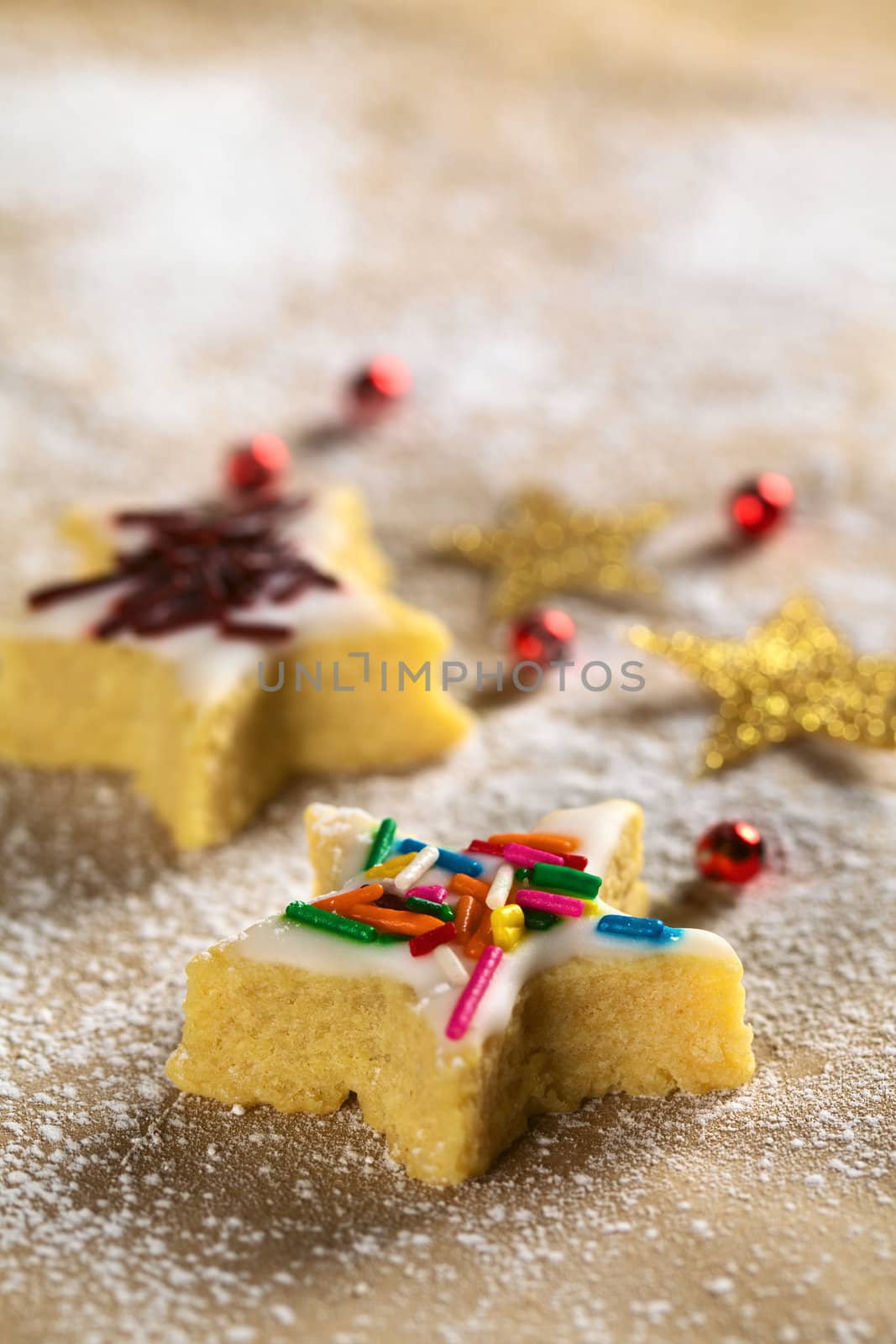 Star-shaped cookie with colorful sprinkles on top (Selective Focus, Focus on the two horizontal star arms in the front)