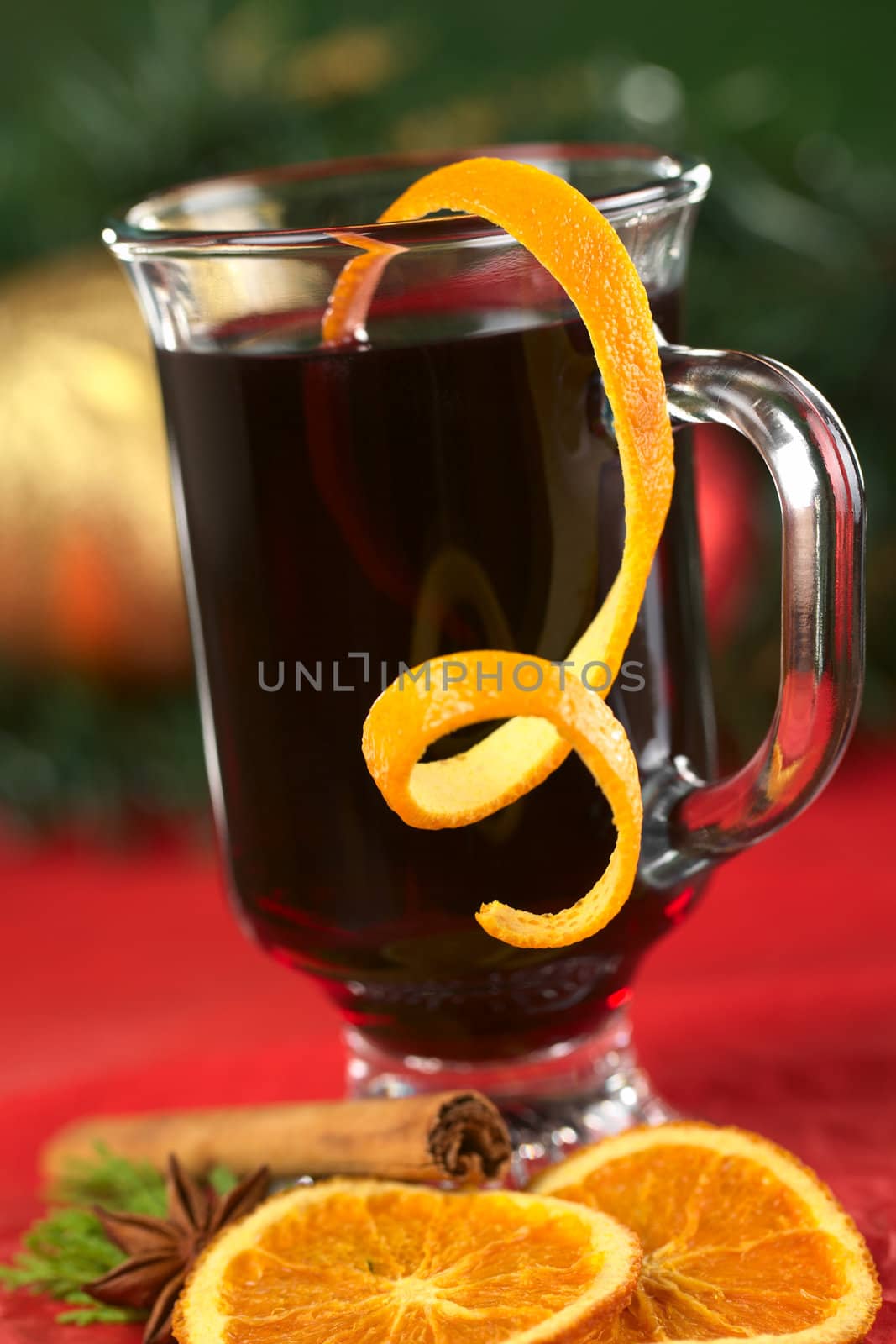 Hot spiced mulled wine garnished with orange peel (Selective Focus, Focus on the front rim of the glass and the orange peel at the rim)