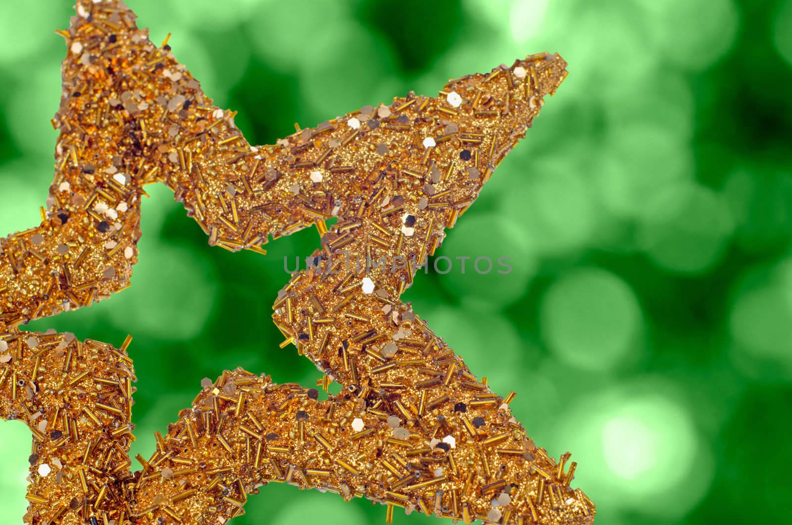 Closeup of golden star on abstract green light background.