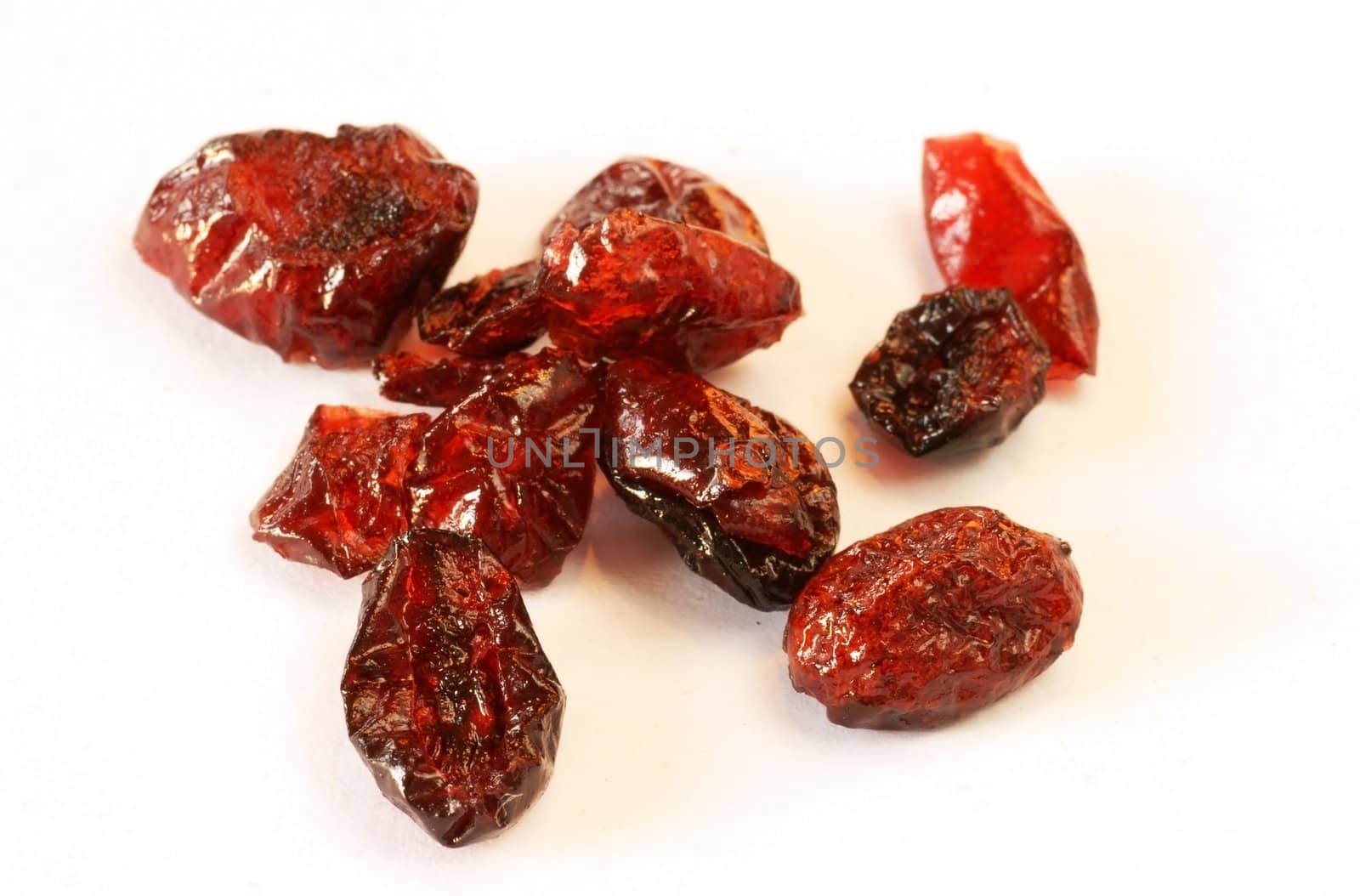 several dried cranberries over white background macro