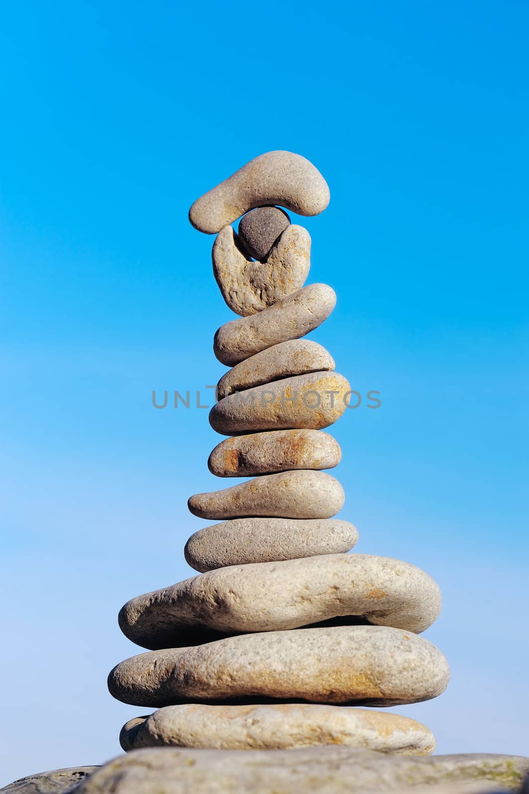 Balancing white pebbles each other on a sky background