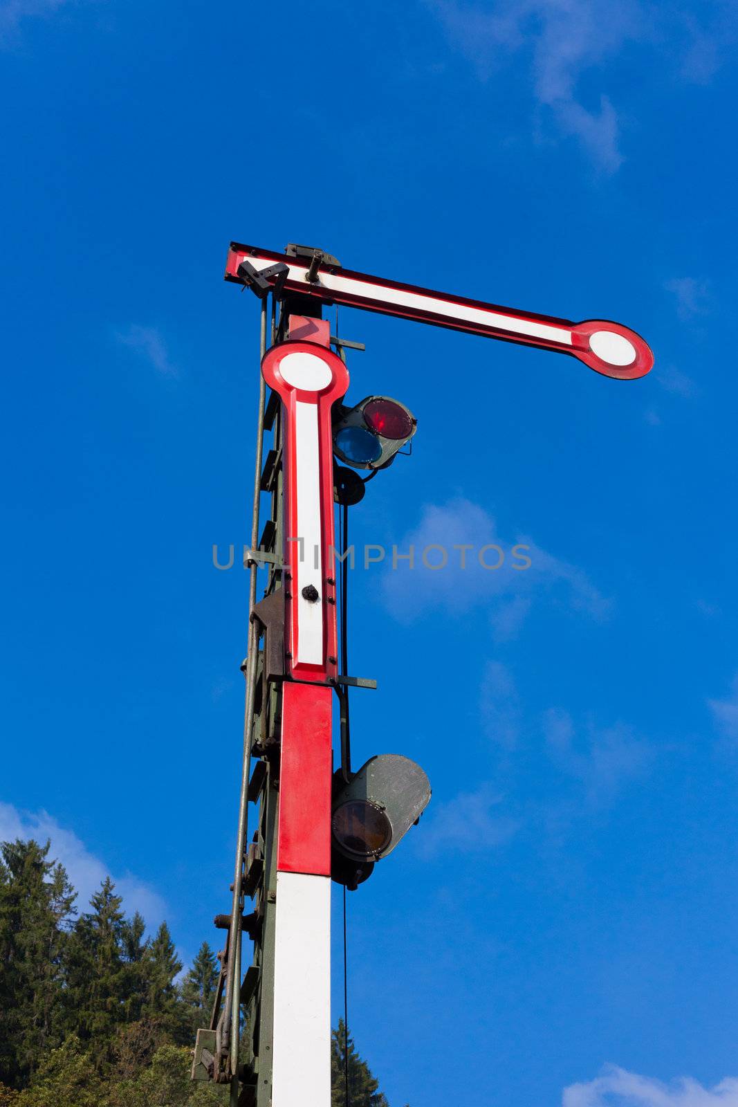 Old railway semaphore against blue sky.