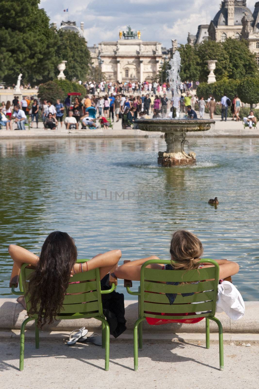 French women relaxing by an ornamental lake in the Jardin des Tuileries in Paris, France