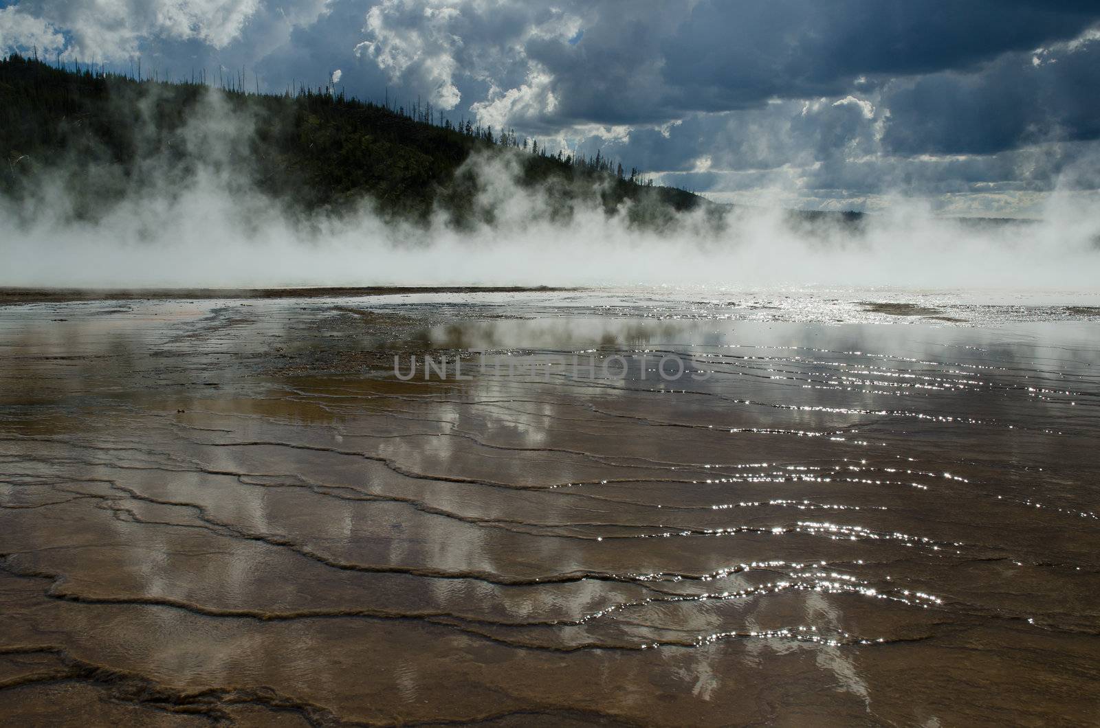 Grand Prismatic Spring, a forested ridge and low clouds, Yellowstone National Park, Wyoming, USA