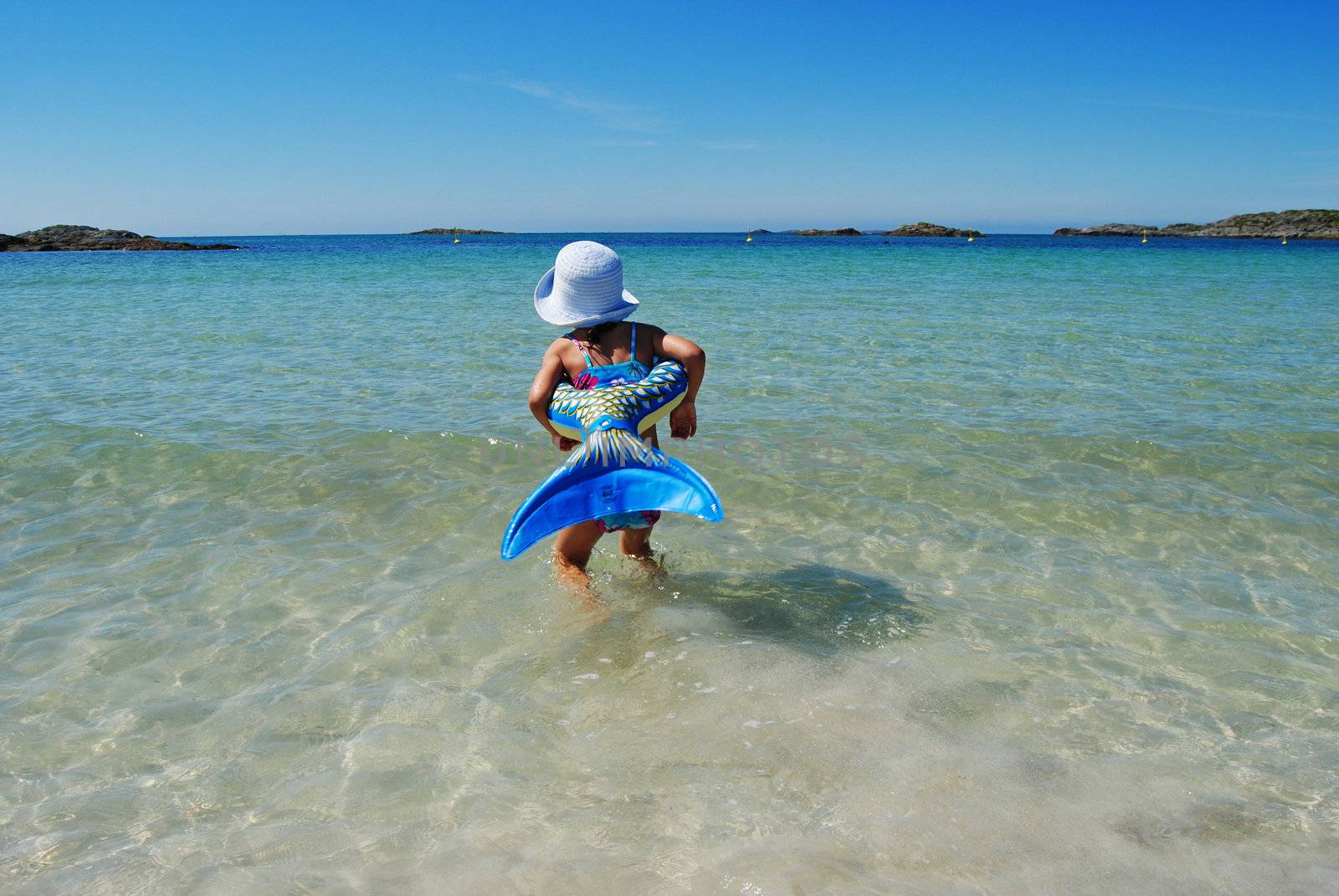 girl walking in the water with inflatable fish