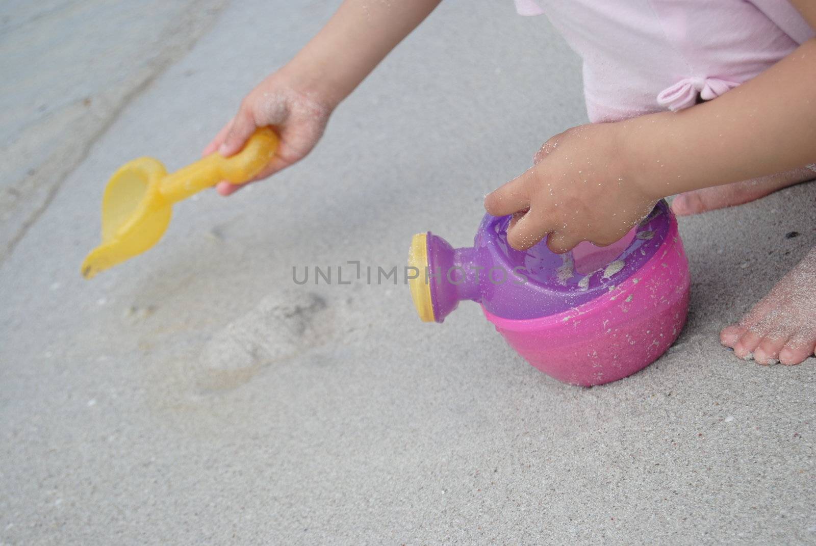kids hands playing with beach toys