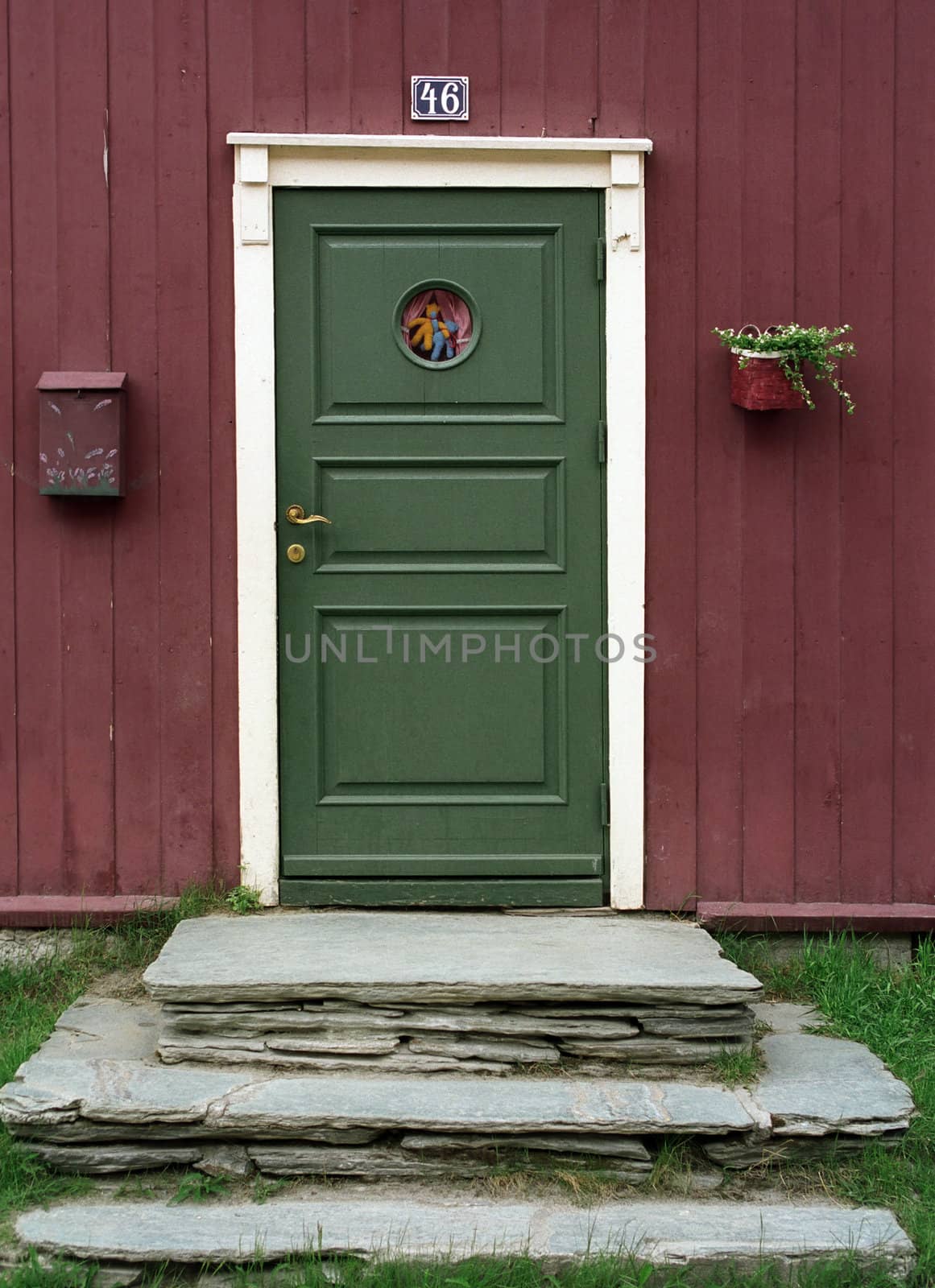 Green door, red woody wall and stone stairs