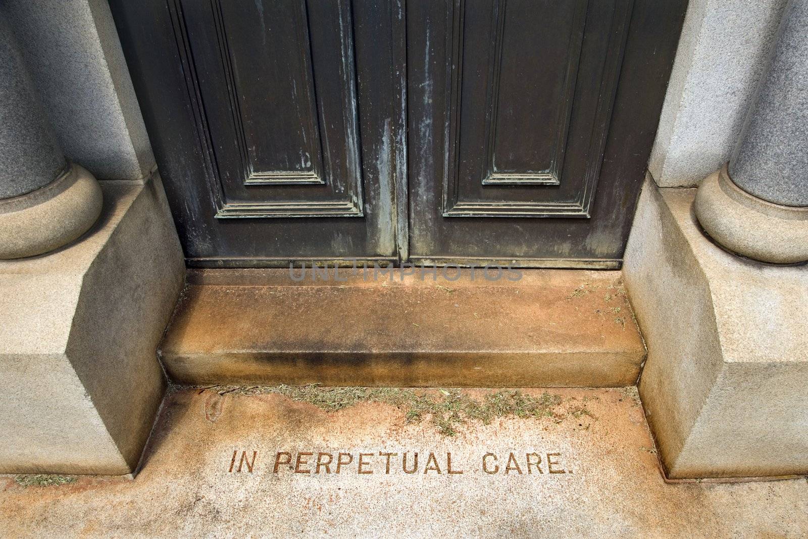 Entrance to mausoleum in graveyard with words, "In Perpetual Care"