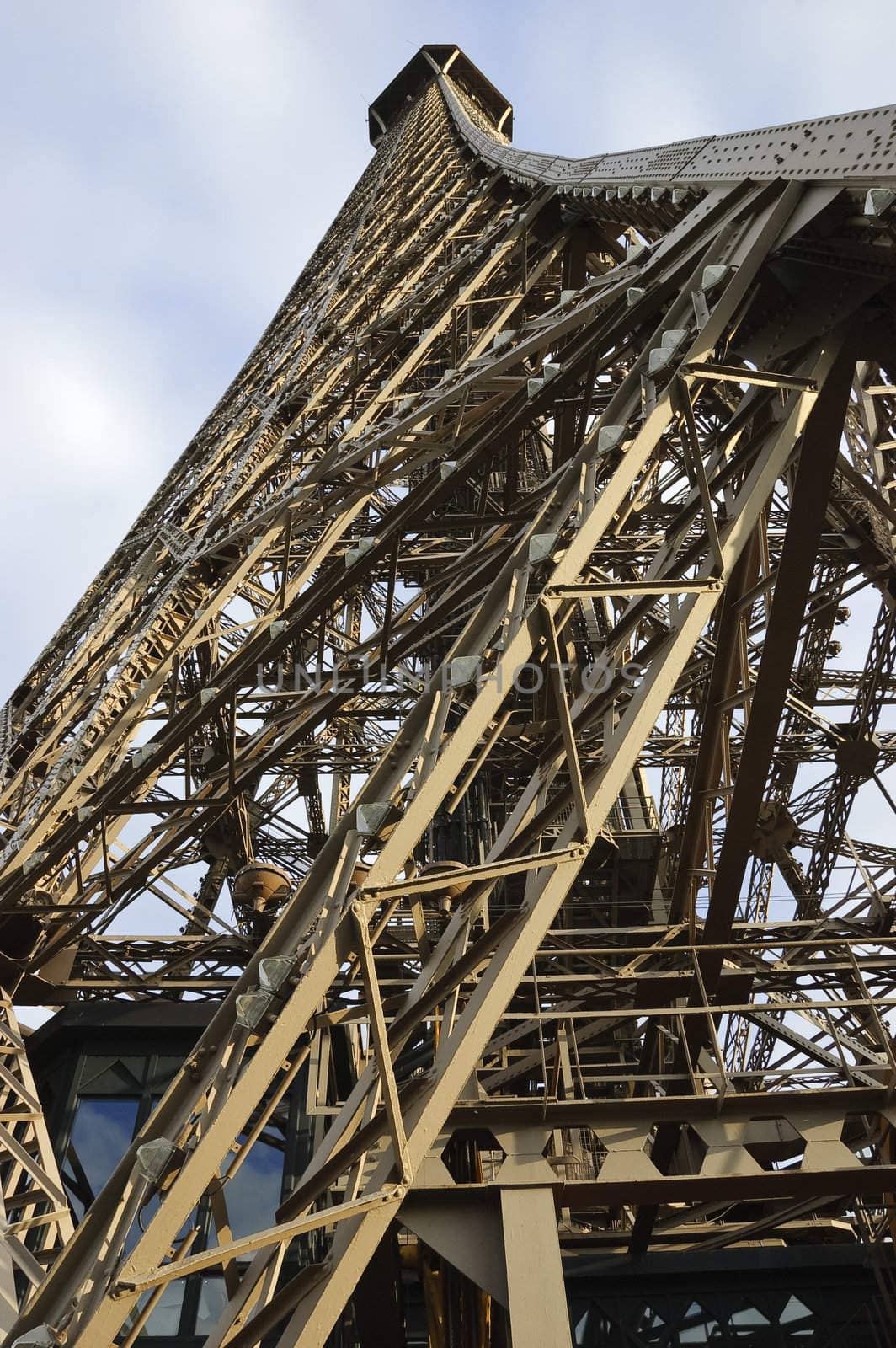 Wide-angle view of Eiffel Tower, Paris, France, from below showing details of iron structure against blue sky