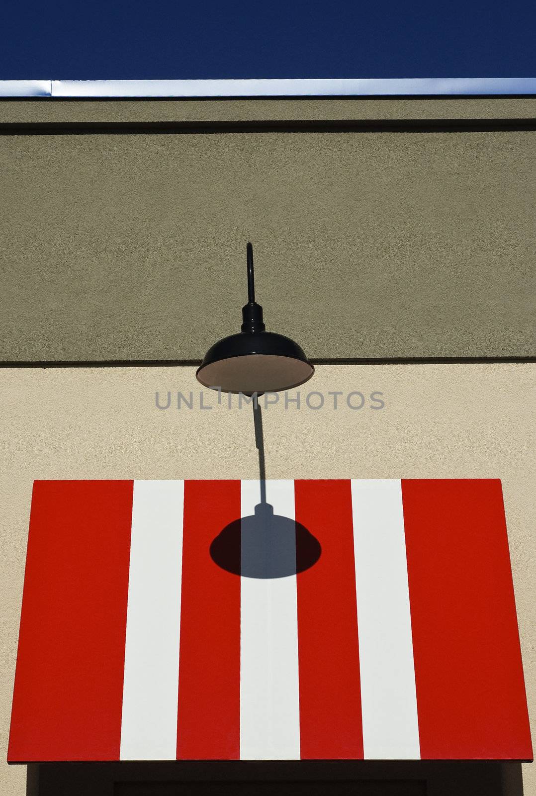 Red and white awning with black street lamp