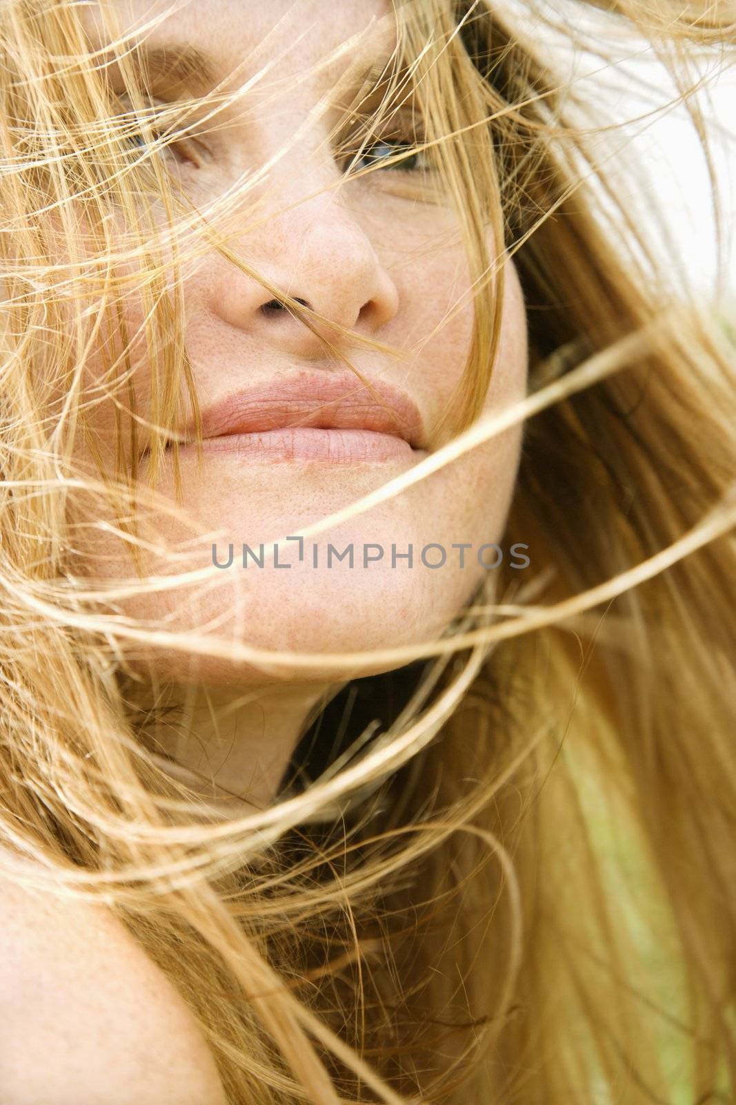 Close up portrait of attractive redheaded woman with windblown hair.