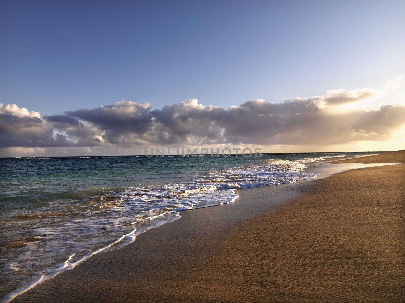 Waves lapping on the beach at dusk in Maui, Hawaii.