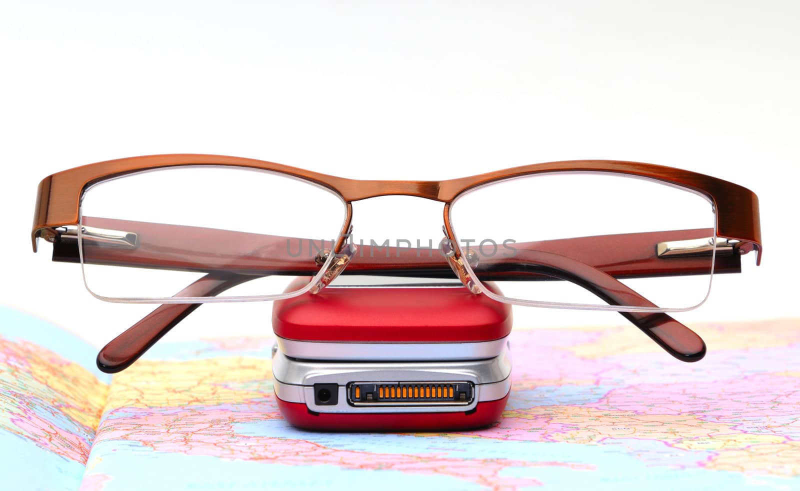 Modern glasses on telephone, background map and white
