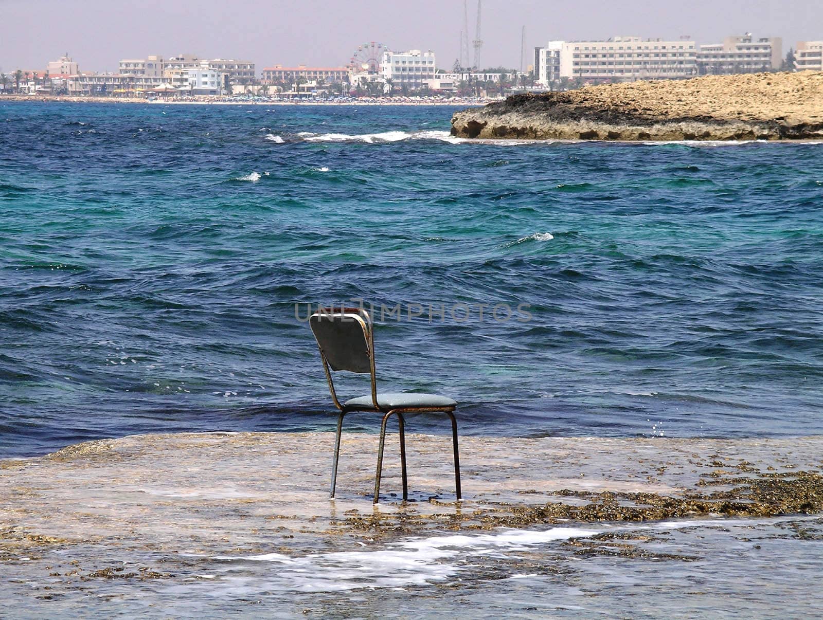 Abandoned old chair laying next to the ocean