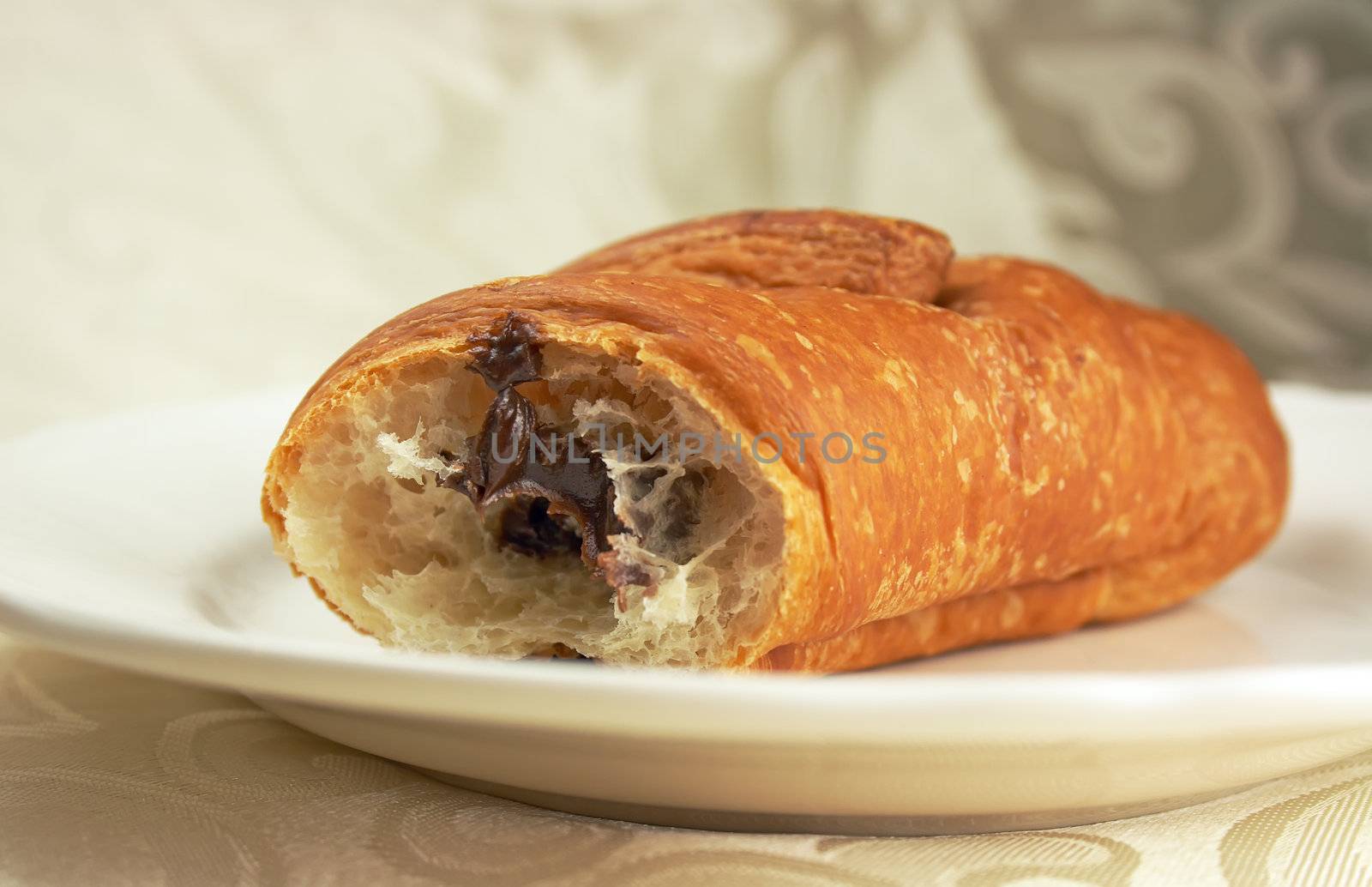 Sweet chocolate croissant on the plate