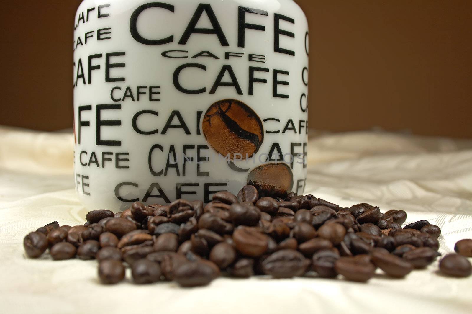 Jar and coffee beans on tablecloth