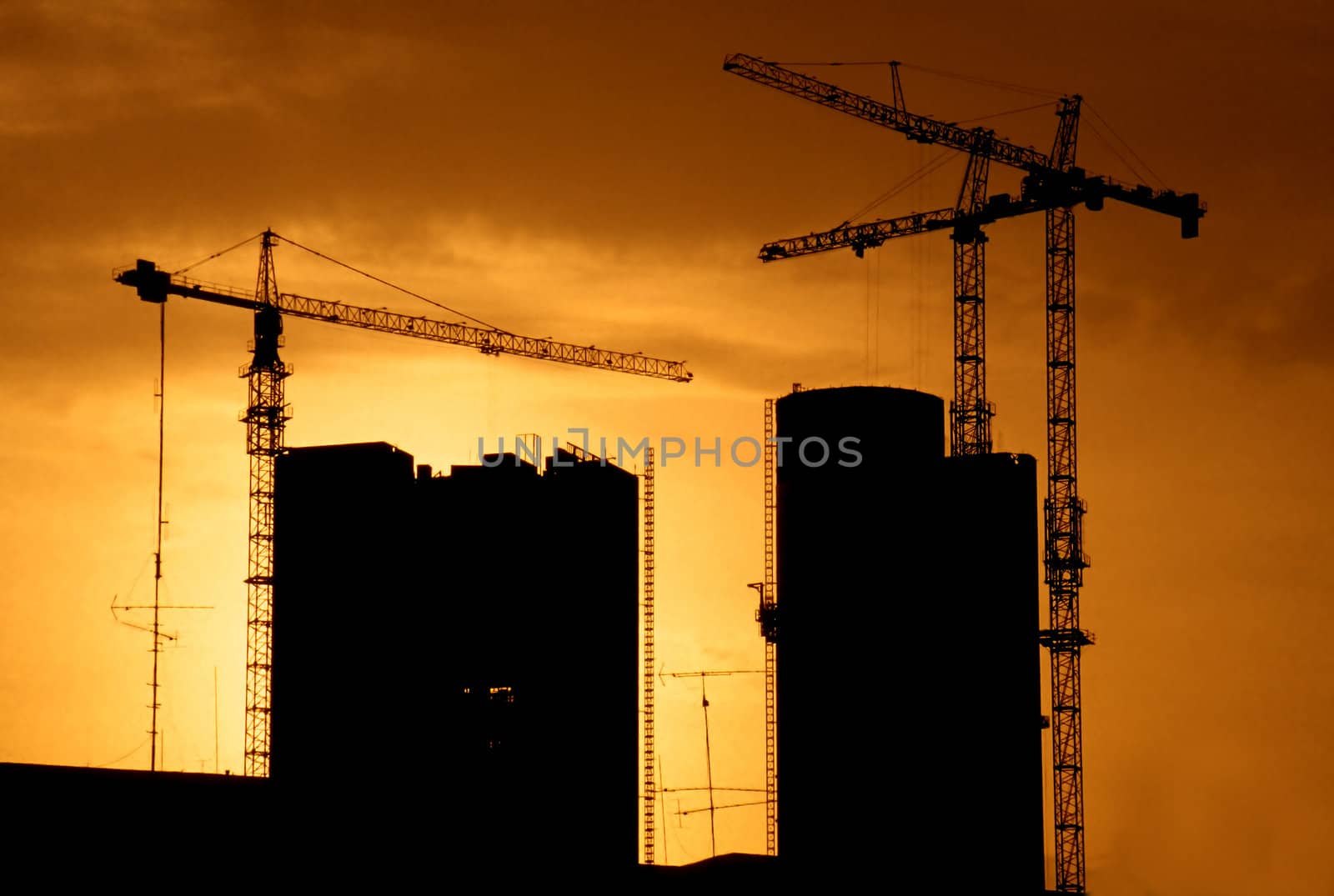Two buildings going up as sun is setting