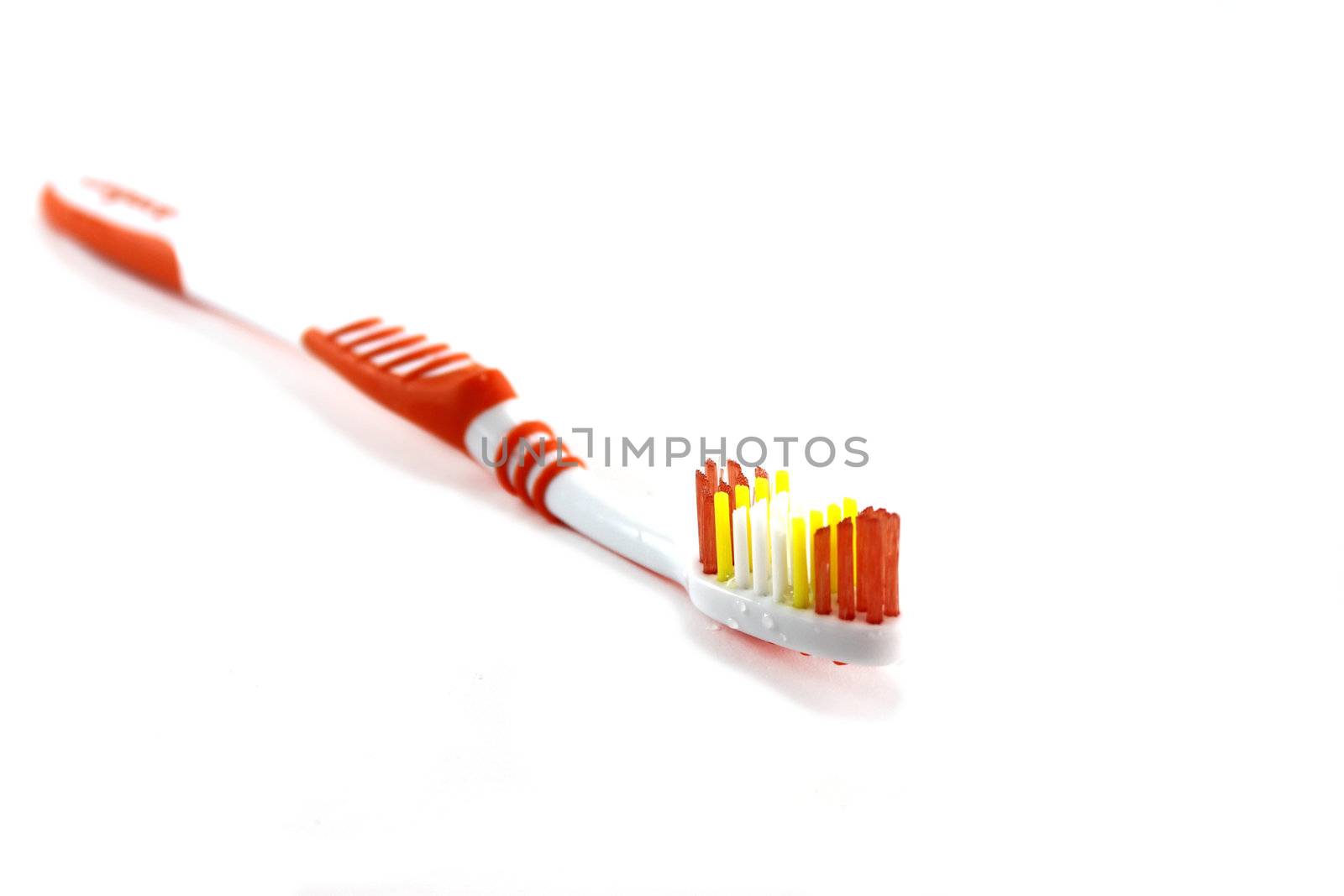 Close up of a orange toothbrush over white background