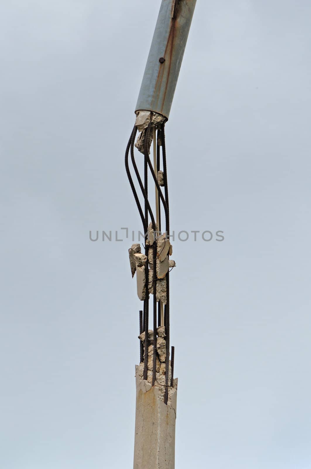 Broken concrete pole and rusty steel bars. Industrial detail.