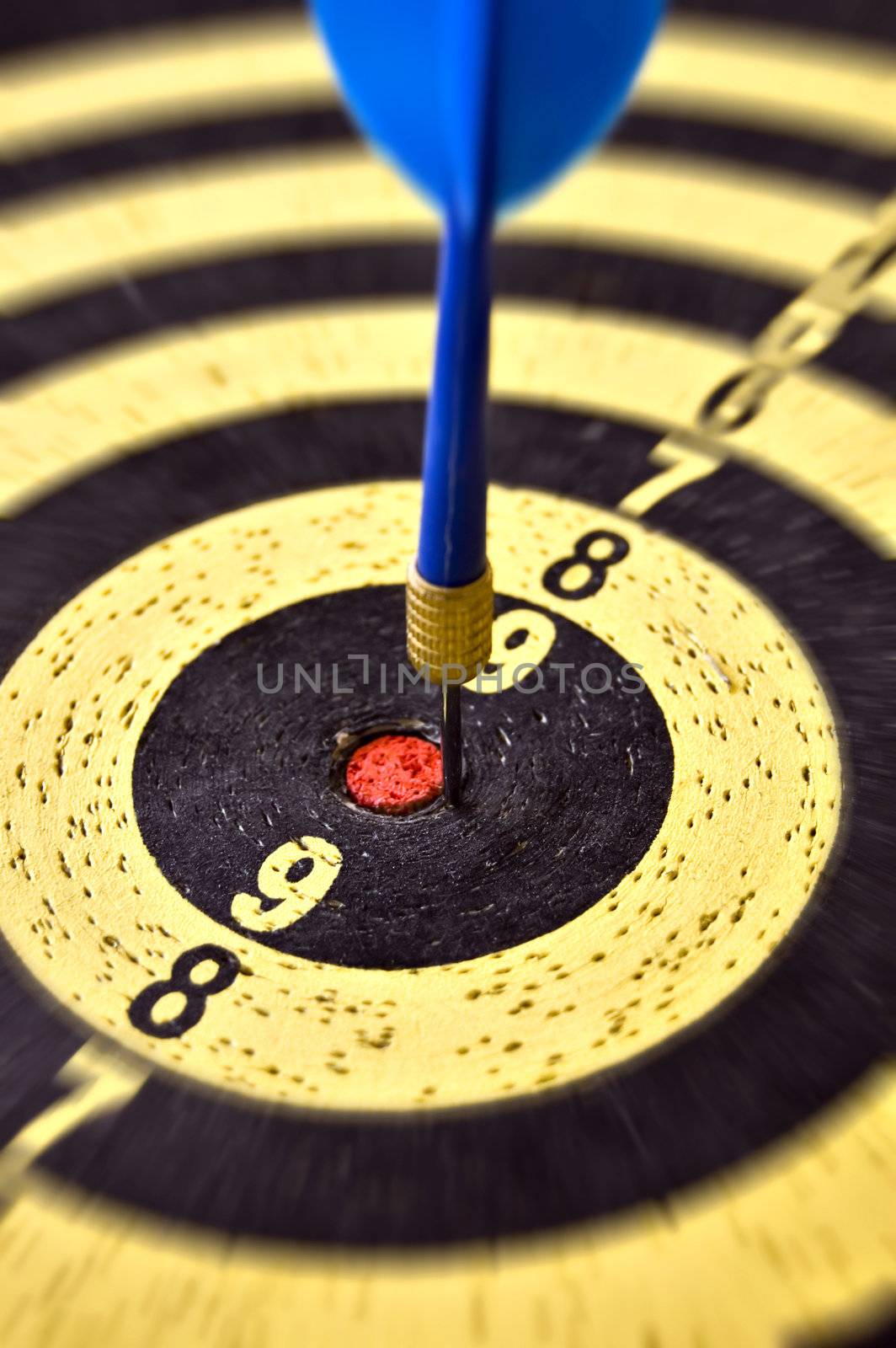 Dartboard target and blue dart arrow. Selective focus.