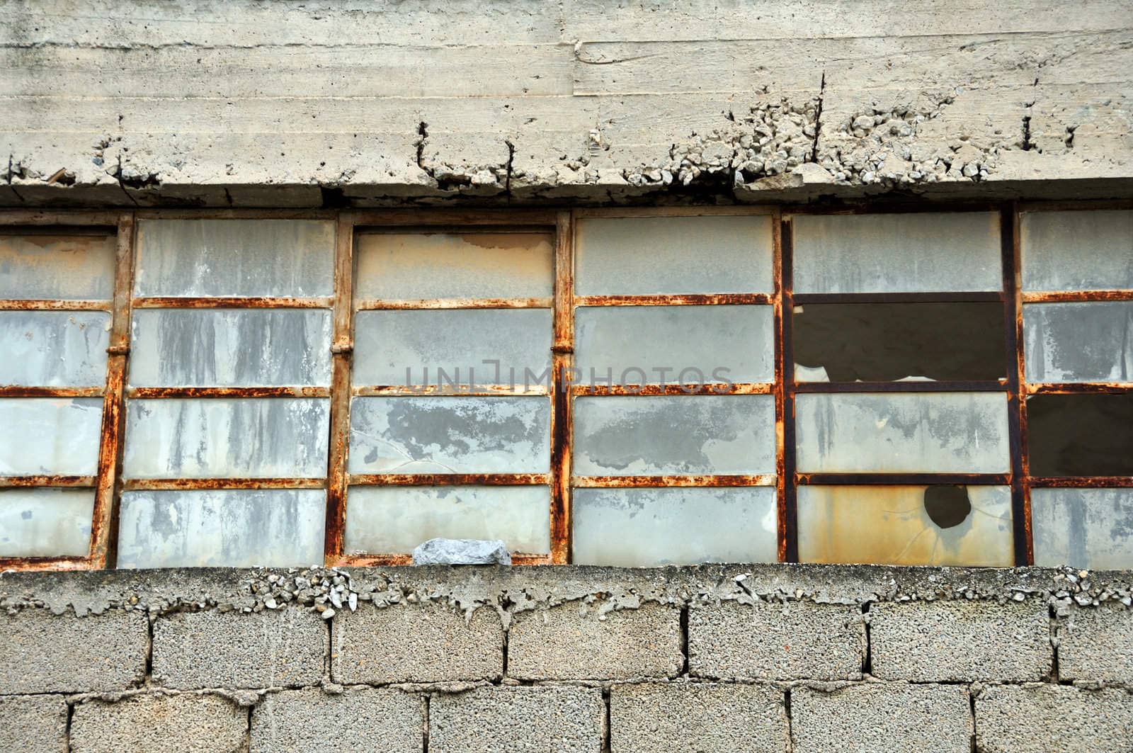 Old factory cinder block wall and broken windows.