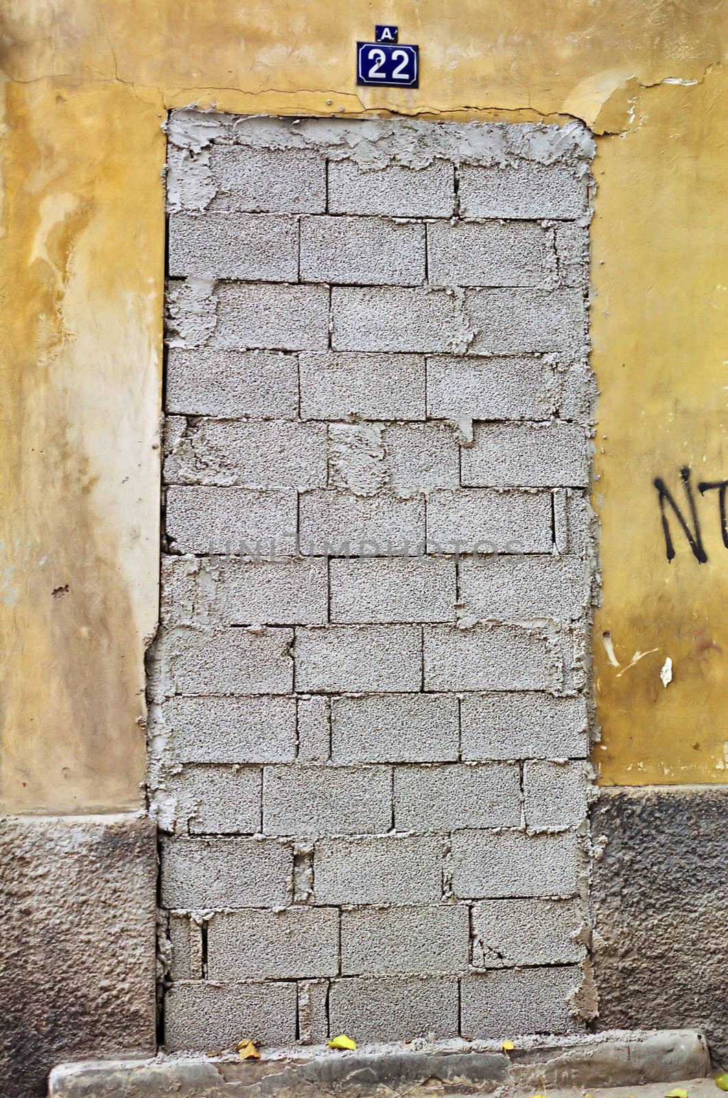 Bricked up door and weathered wall of an abandoned building.