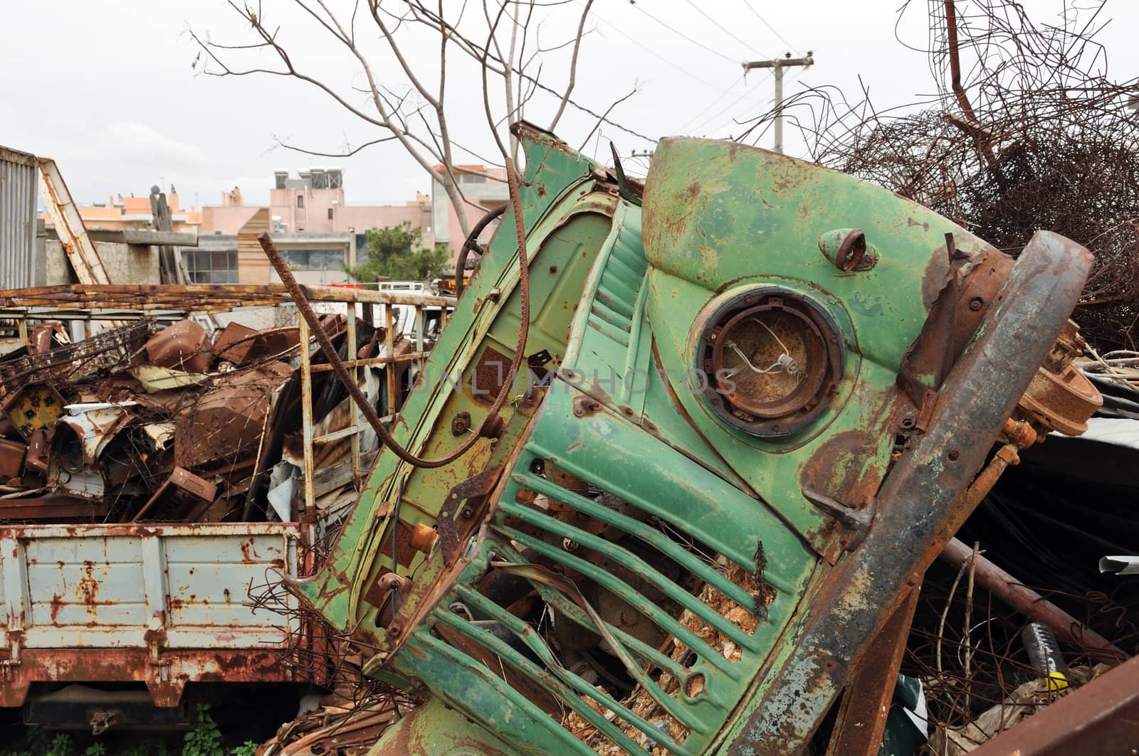 Rusty vintage car and scrap metal at a junkyard.