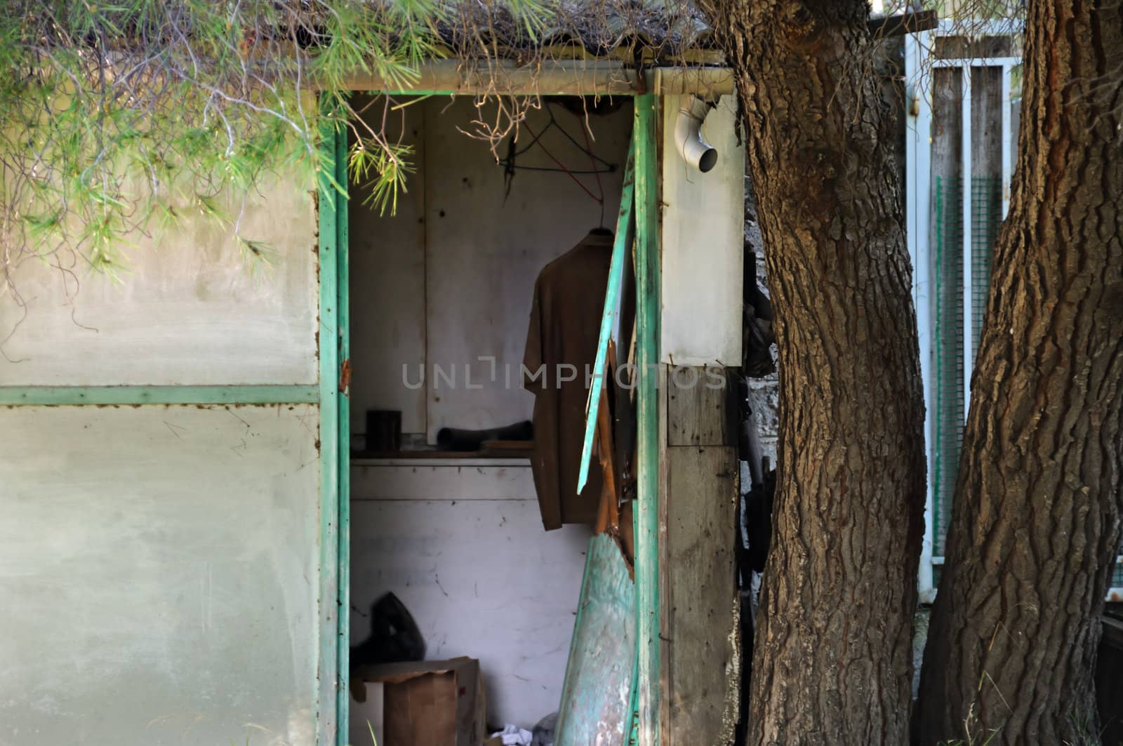 Broken door of an abandoned house and hanging shirt.