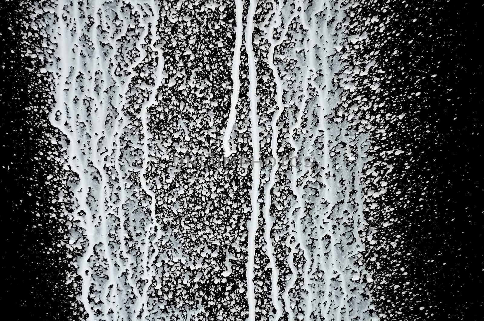 White paint splashed over black background. Abstract texture.
