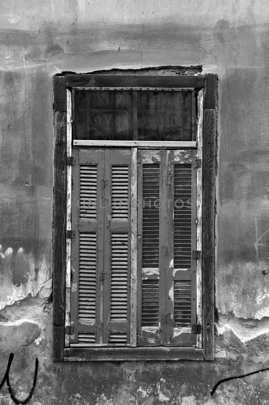 Vintage window shutters and grungy abandoned house wall. Black and white.