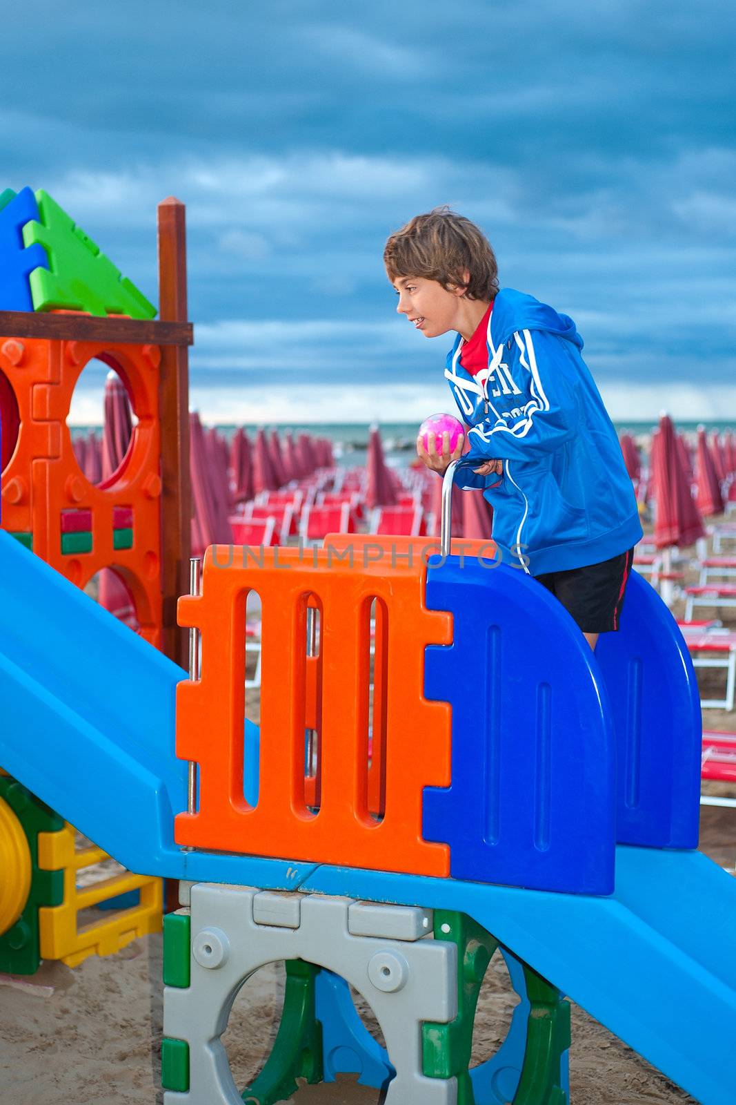 a boy on the children's playground at the beach