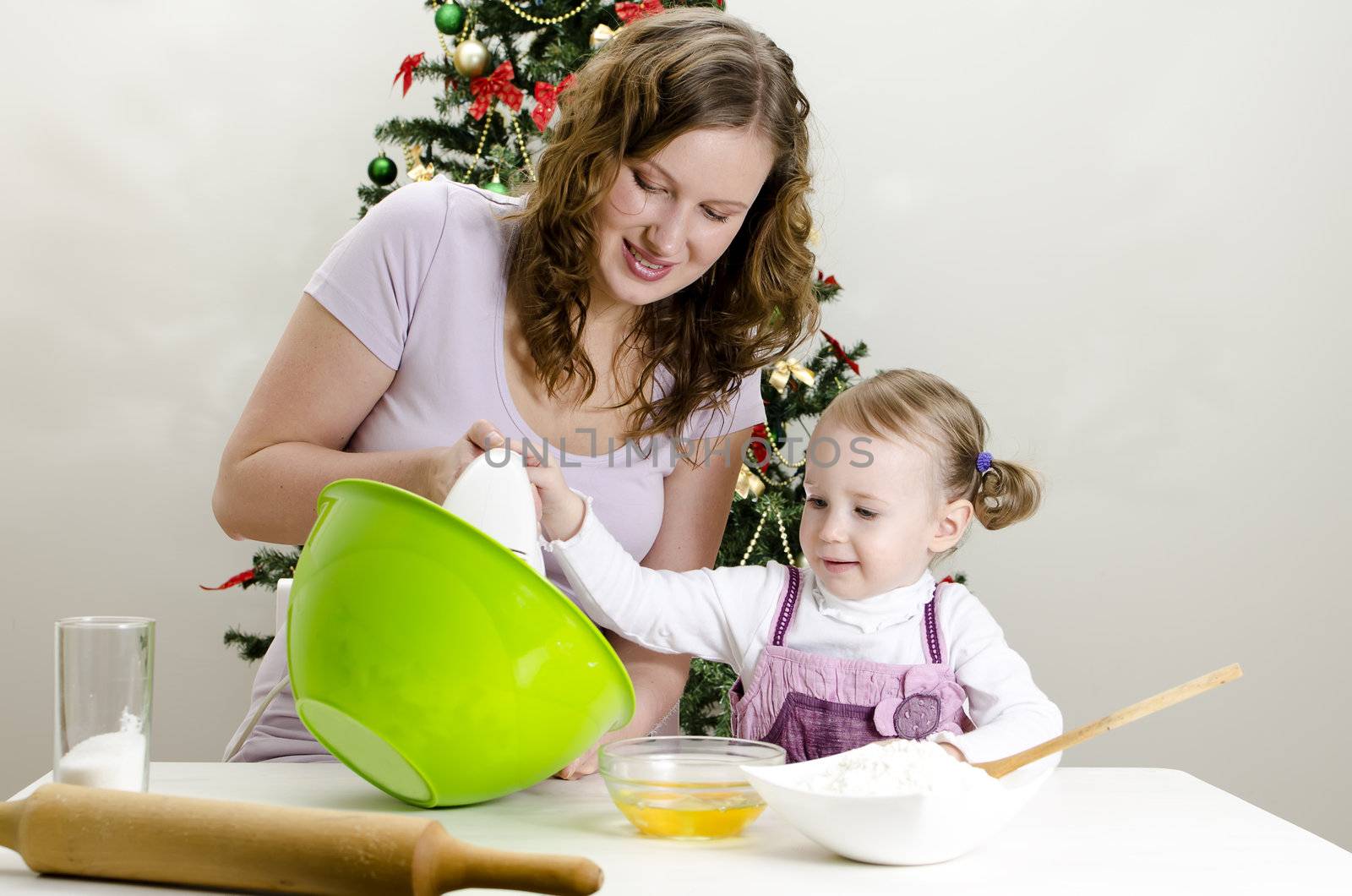 little girl and mother are preparing Christmas cookies