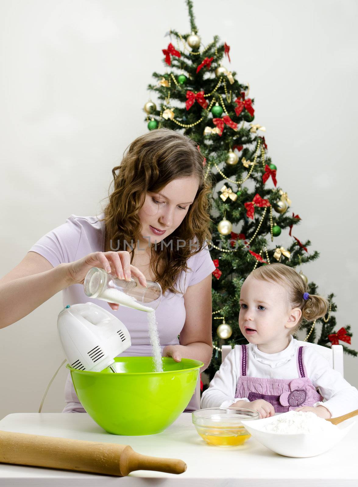 little girl and mother are preparing Christmas cookies