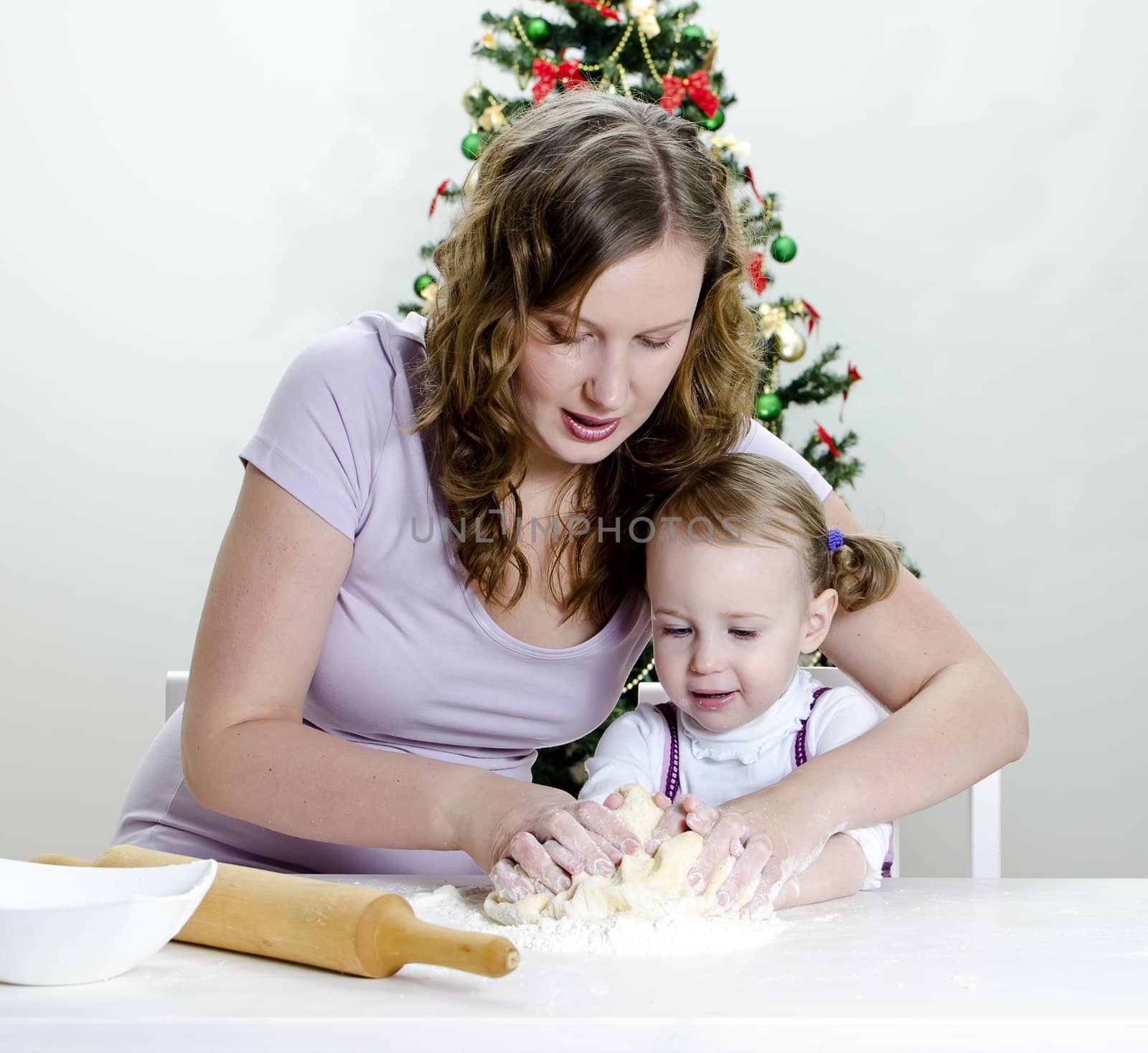 little girl and mother are preparing Christmas cookies