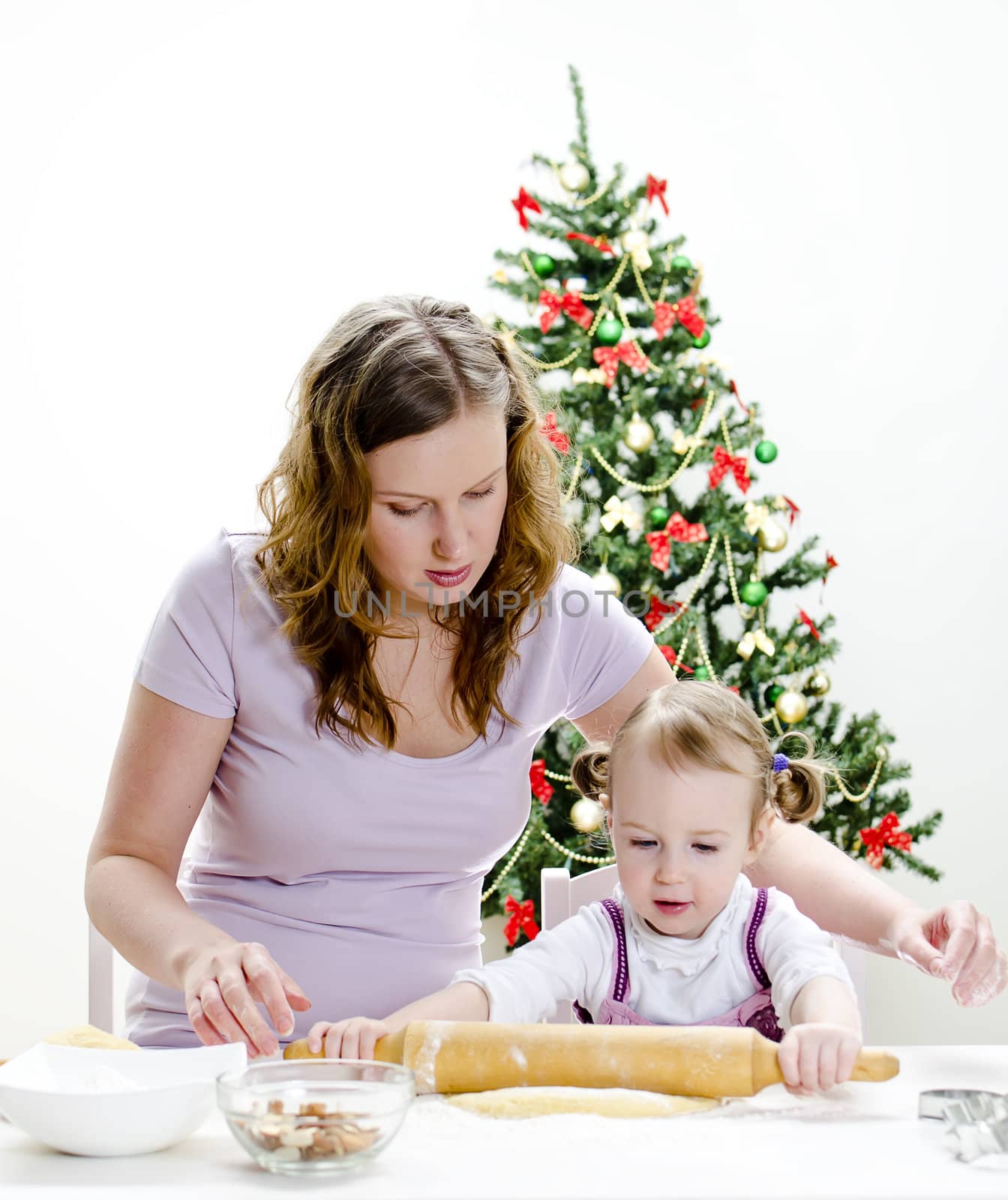 little girl and mother are preparing Christmas cookies