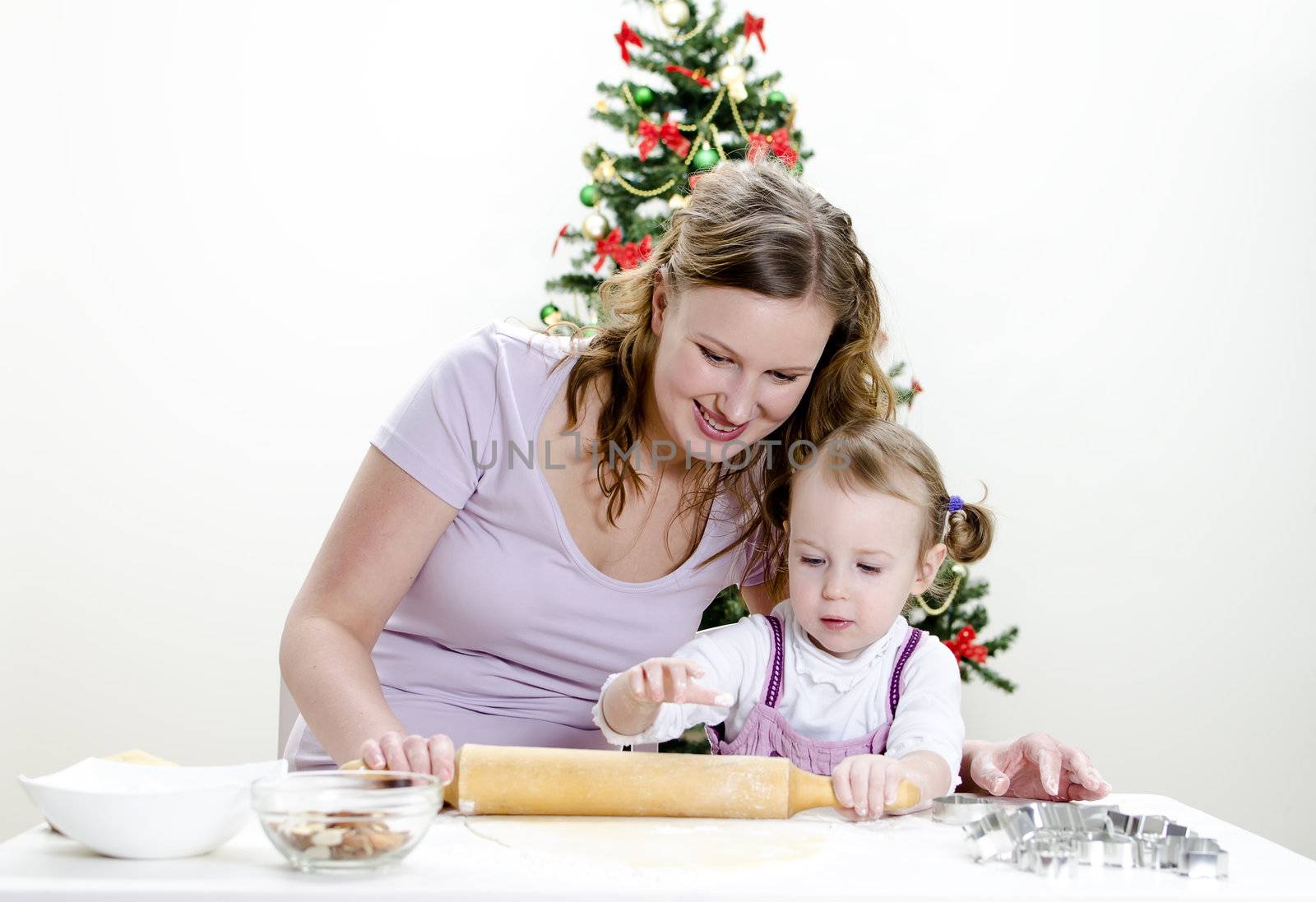 little girl and mother are preparing Christmas cookies